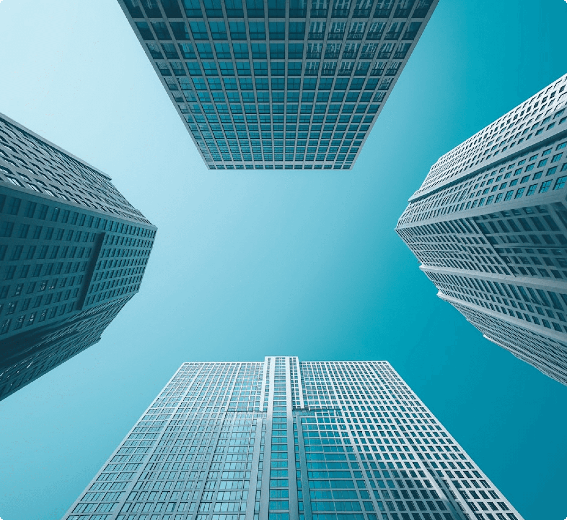 Low-angle view of four tall skyscrapers framing a clear sky.