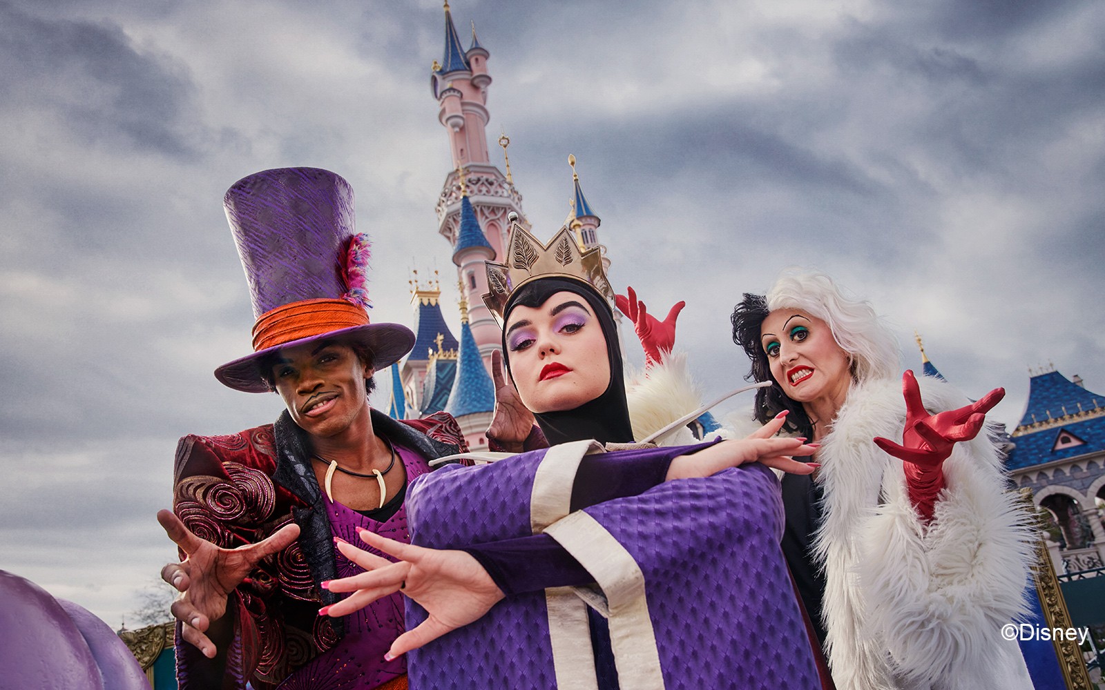 Disney-skurker poserer foran Torneroseslottet i Disneyland Paris under Halloween.