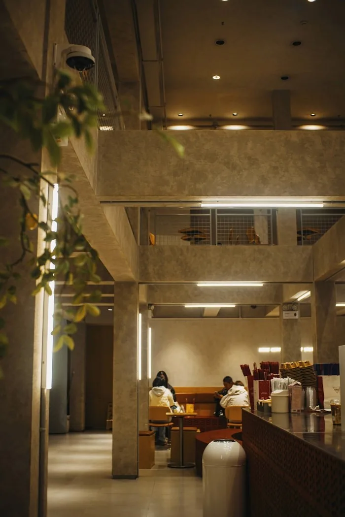 Modern bir kafe içinde masalarda oturan insanlar.