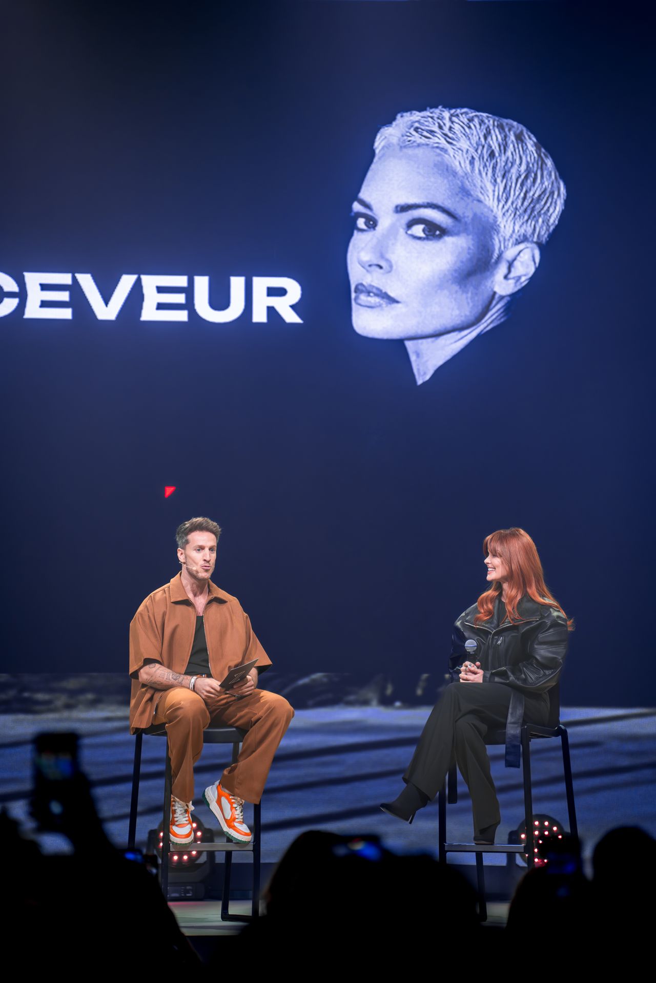 Curved orange bathroom with stone sink and bathtub.