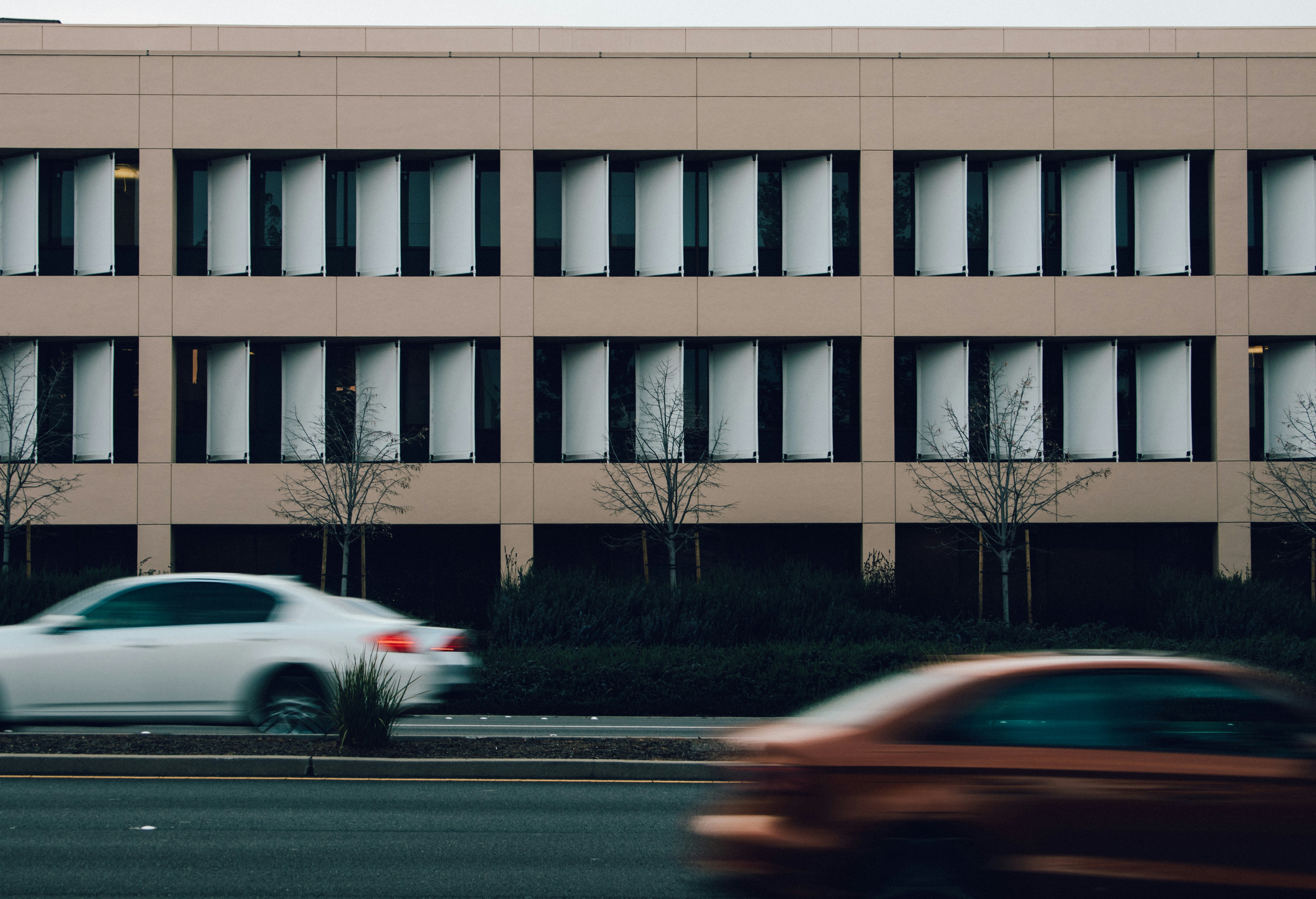 modern building by the road with cars driving by