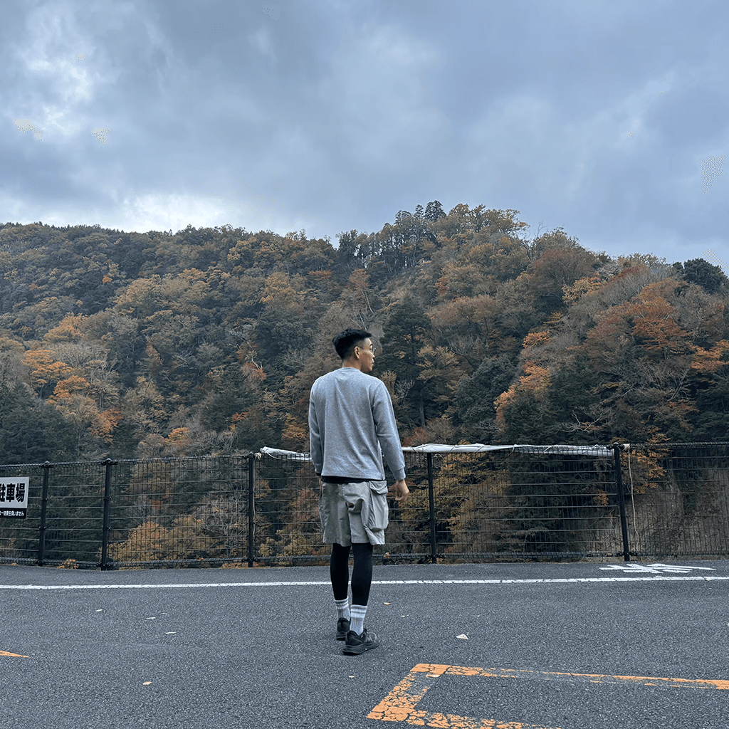 a wide shot of a male person’s back in the backdrop of mountains