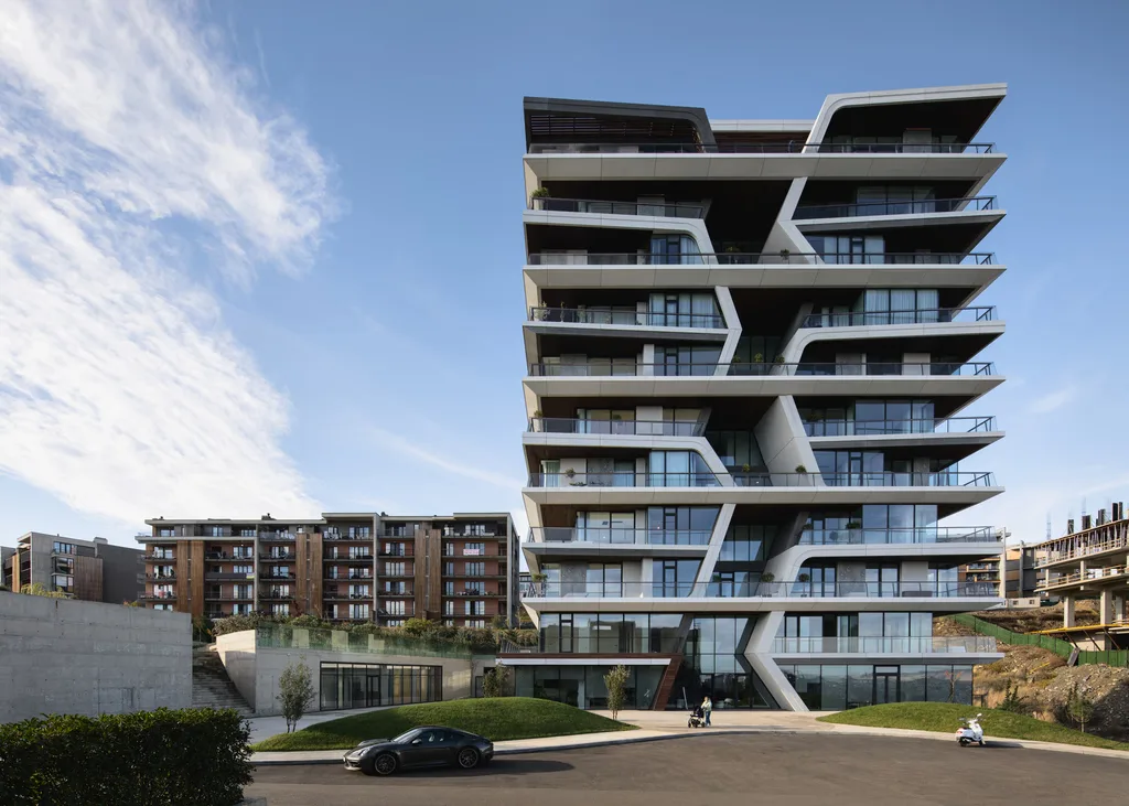 High-rise building with angular balconies and futuristic design, towering over surrounding structures.