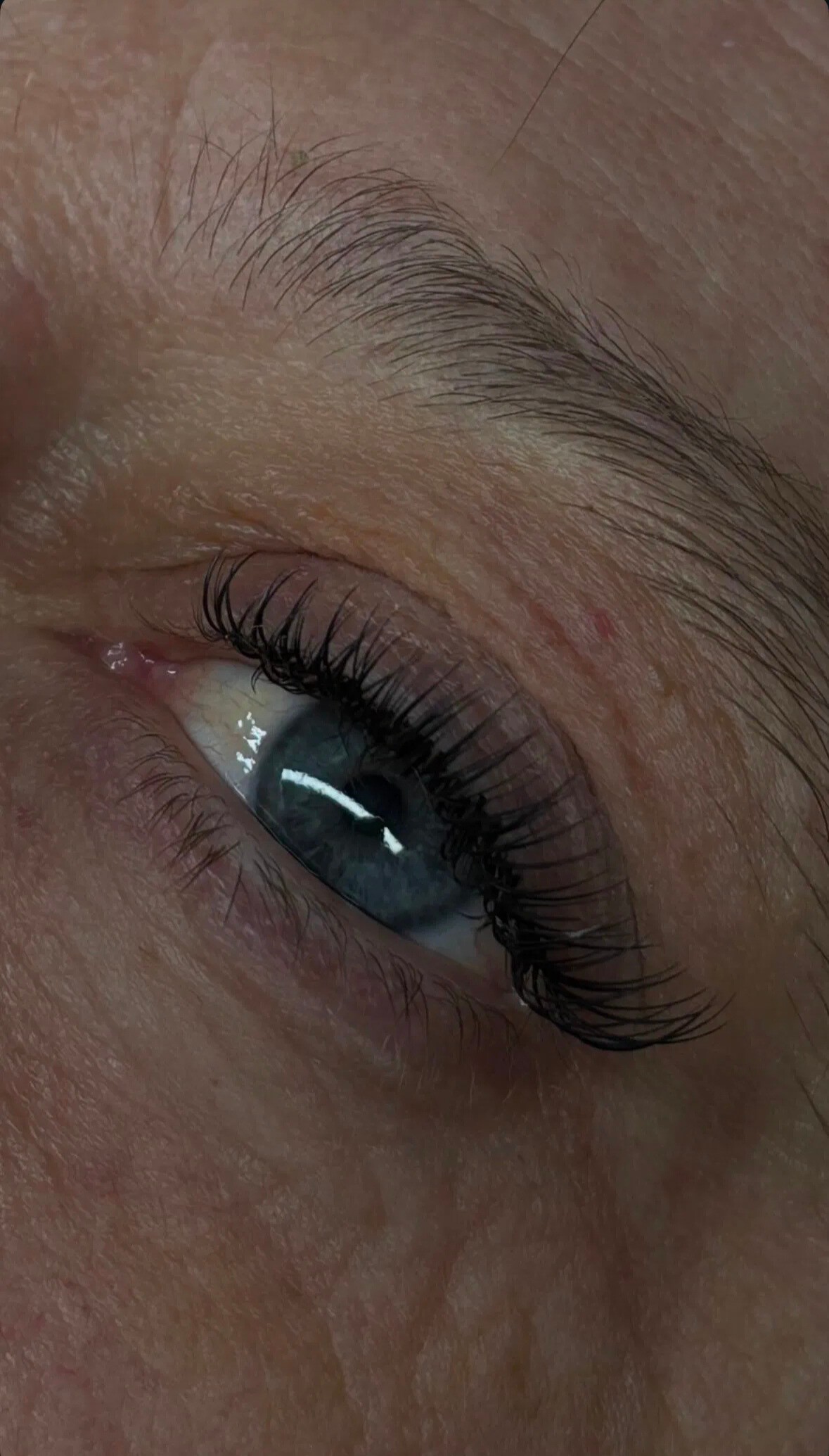 Rehaussement de cils sur œil bleu – cils naturels allongés et recourbés, effet léger et élégant pour un regard frais sans maquillage.