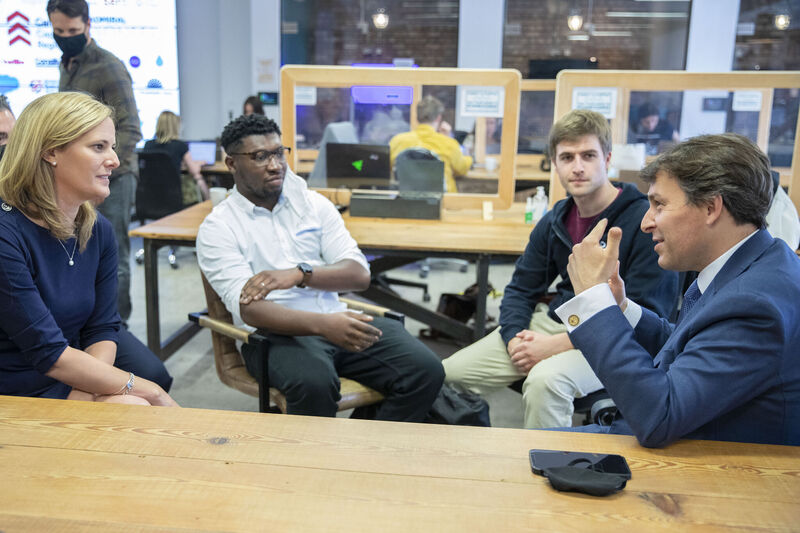 People sitting at desks in a classroom, talking.