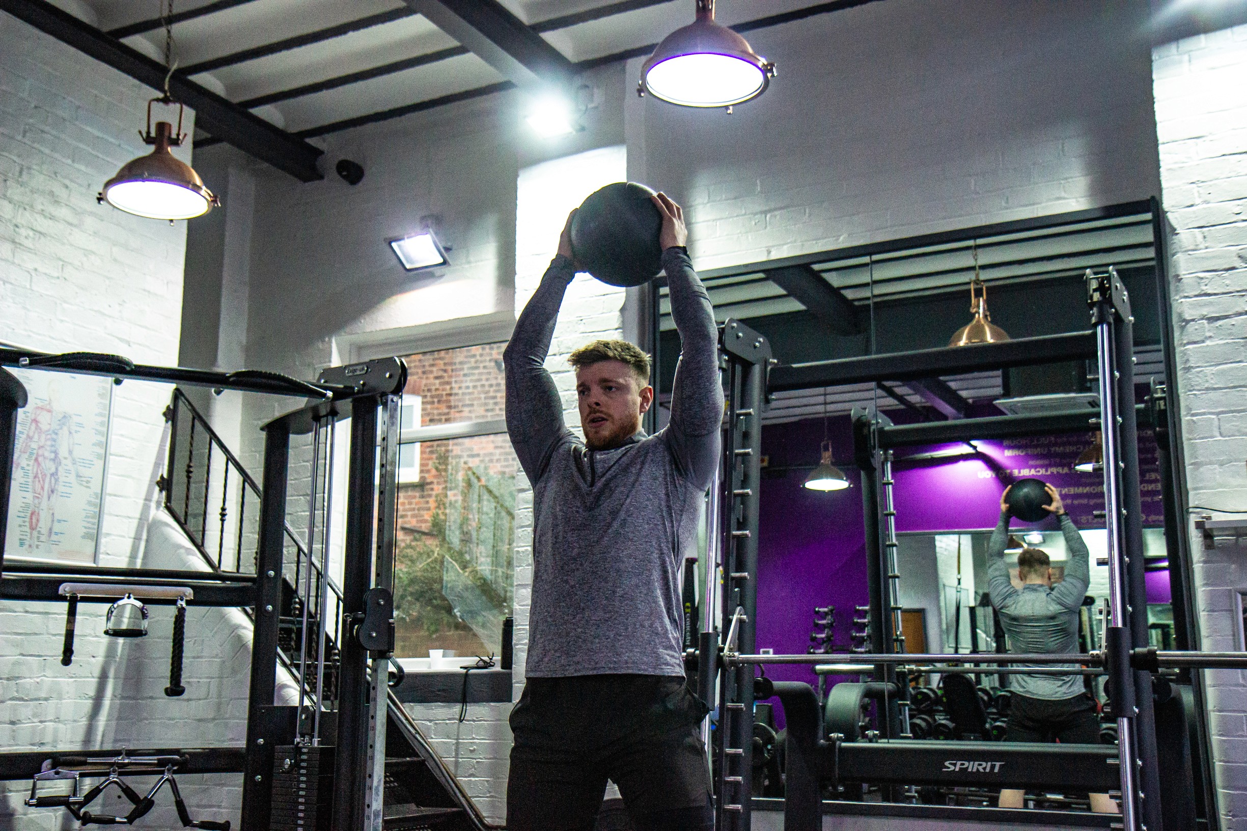Man holding a medicine ball for a HIIT exercise routine.