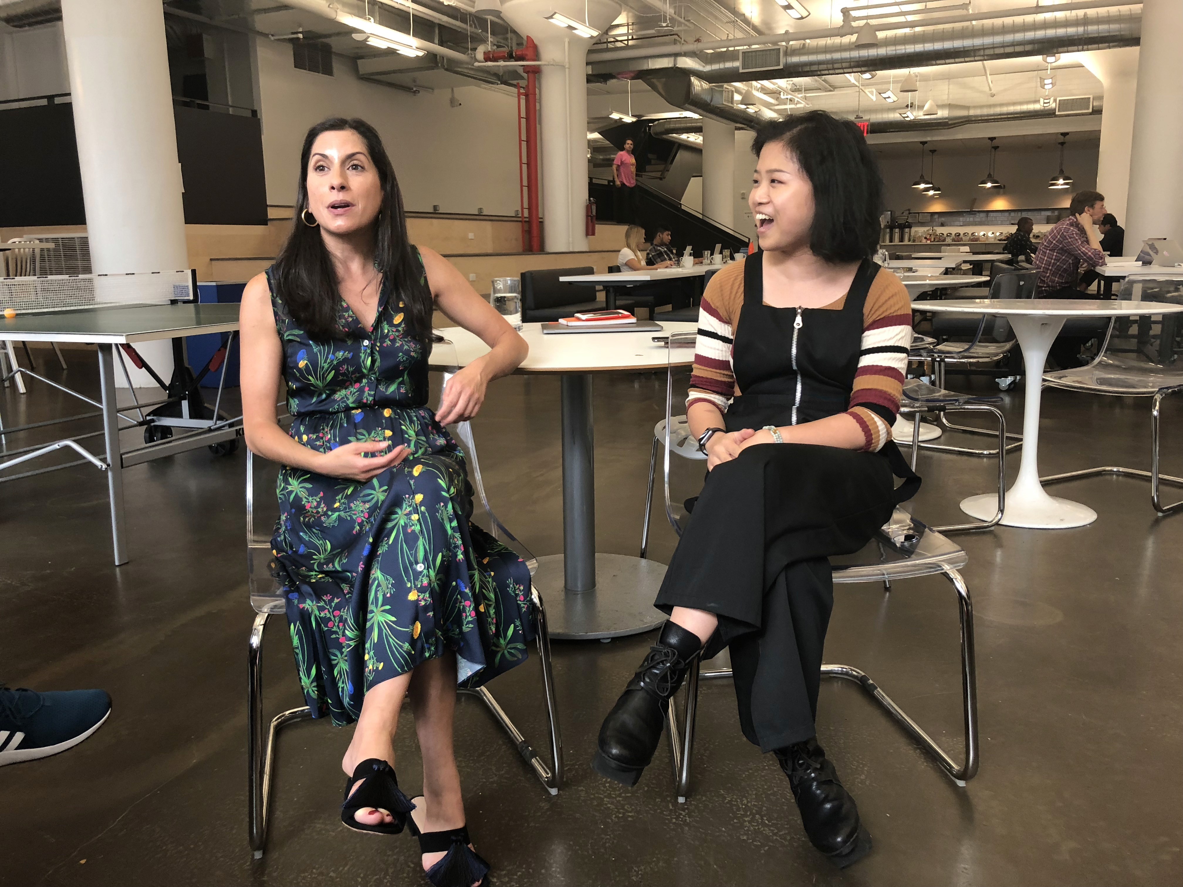 A photo of two girls sitting close to each other on chairs.