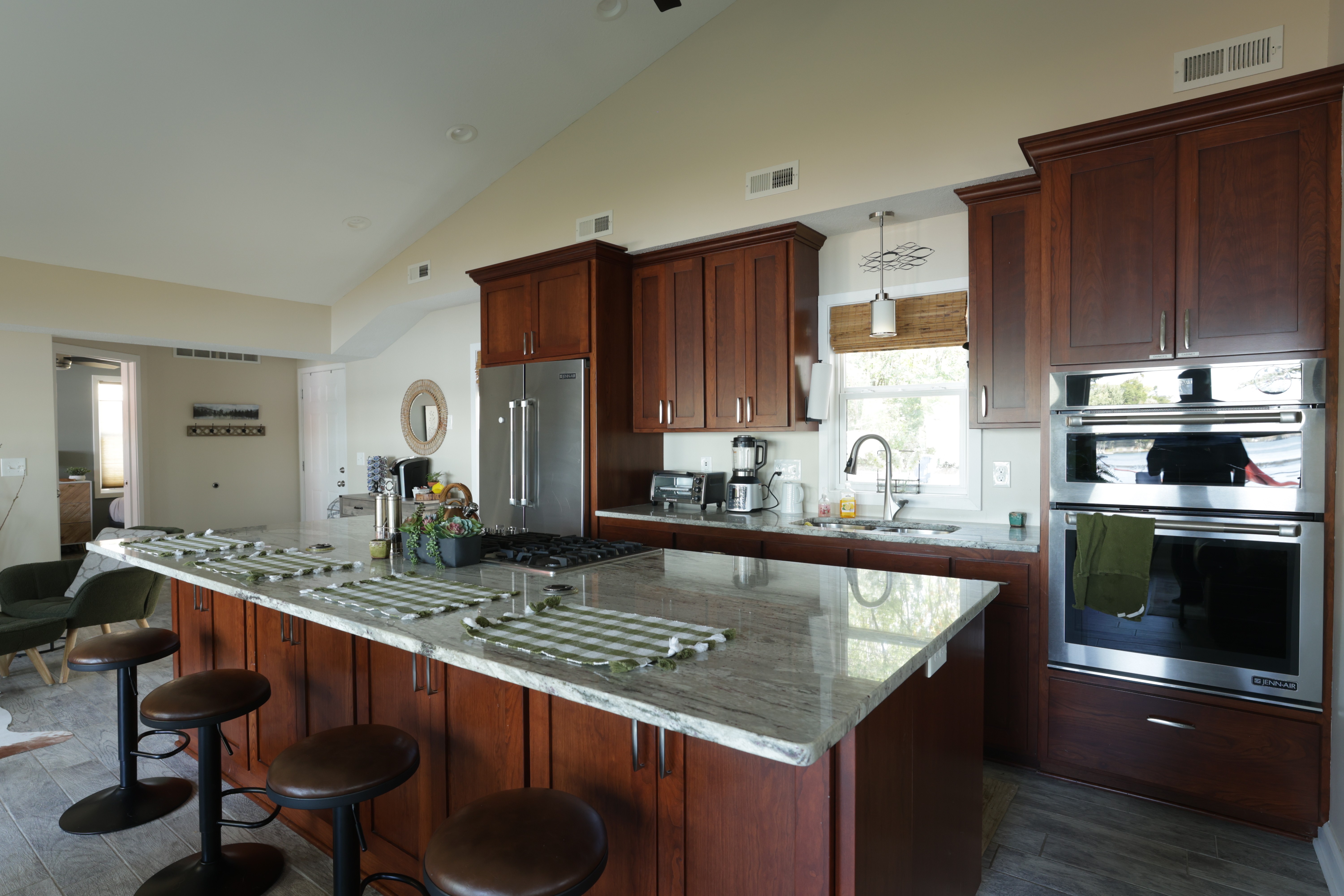 Spacious kitchen with a dark wood island, granite countertops, and stainless appliances.