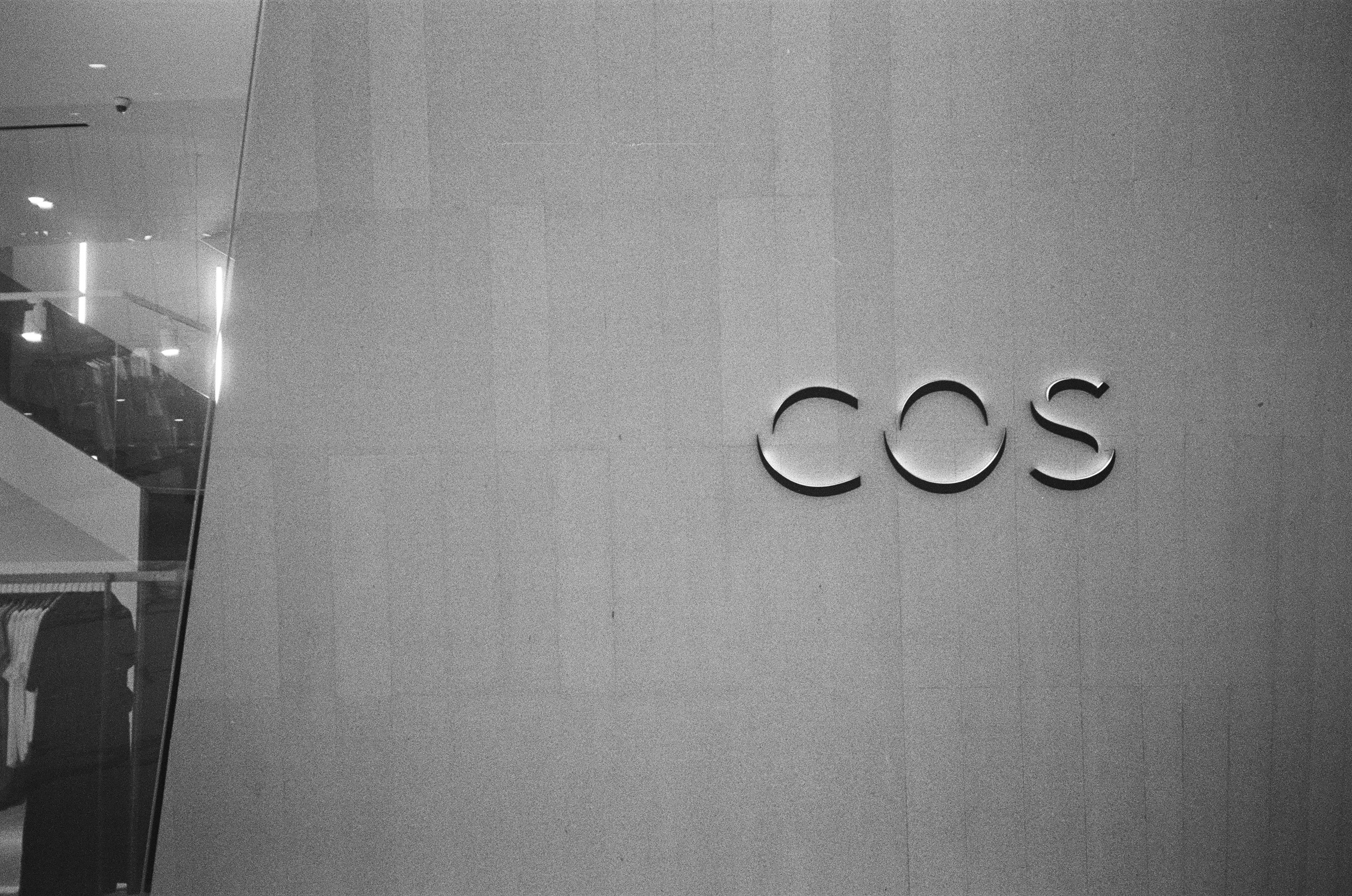 Cos logo on a textured wall