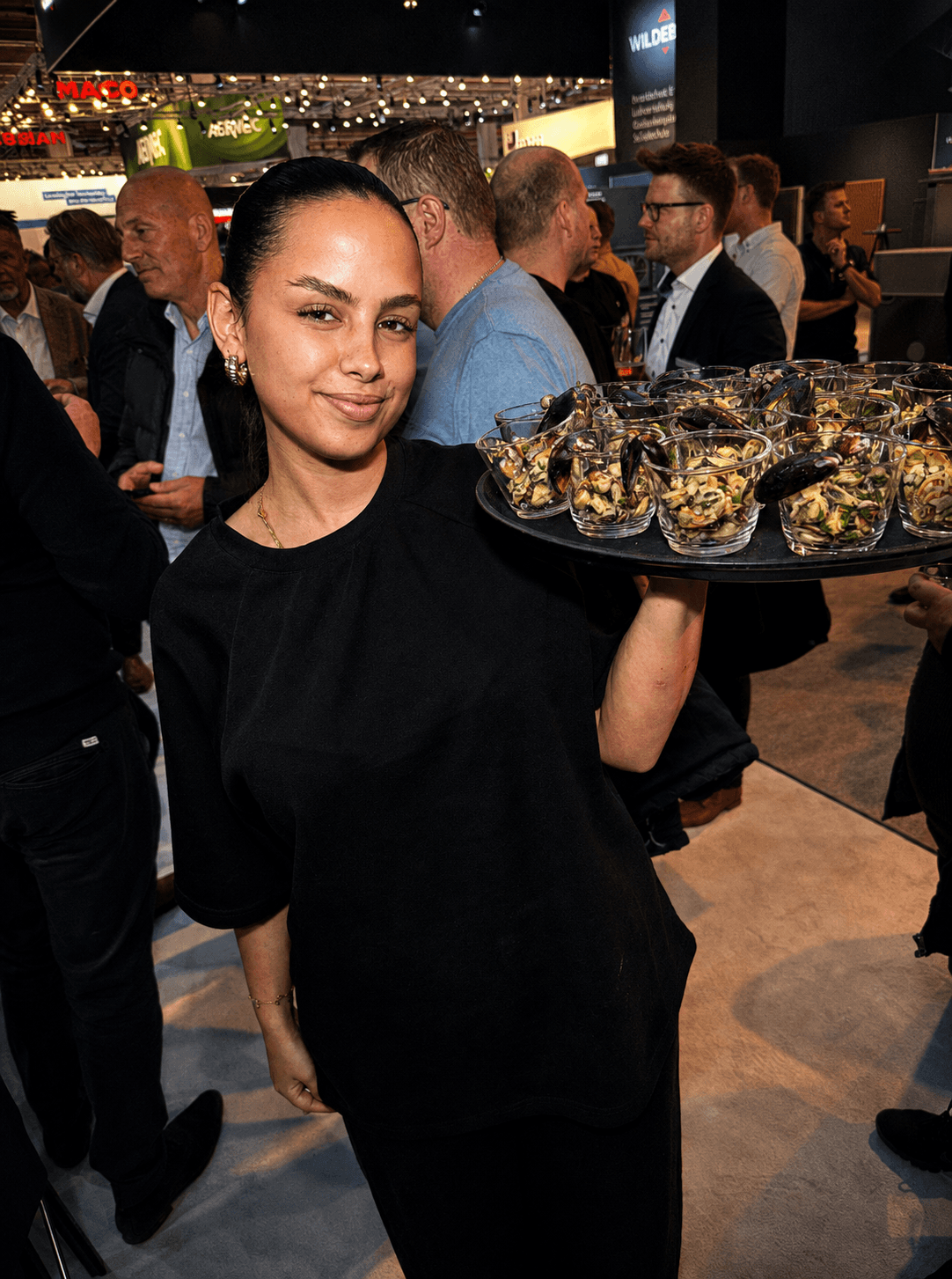 Servicekraft mit Muschel-Catering auf einer Messe – Kellys Catering Mainz, Frankfurt und Wiesbaden
