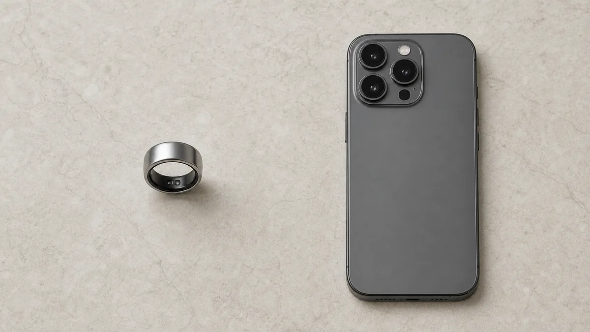 Smart tasbih ring beside a phone placed face down on a light stone surface
