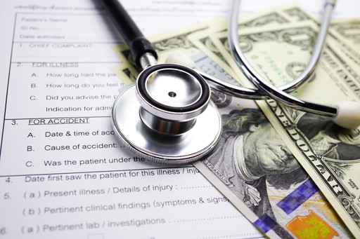 medical claim form next to money and a medical tools
