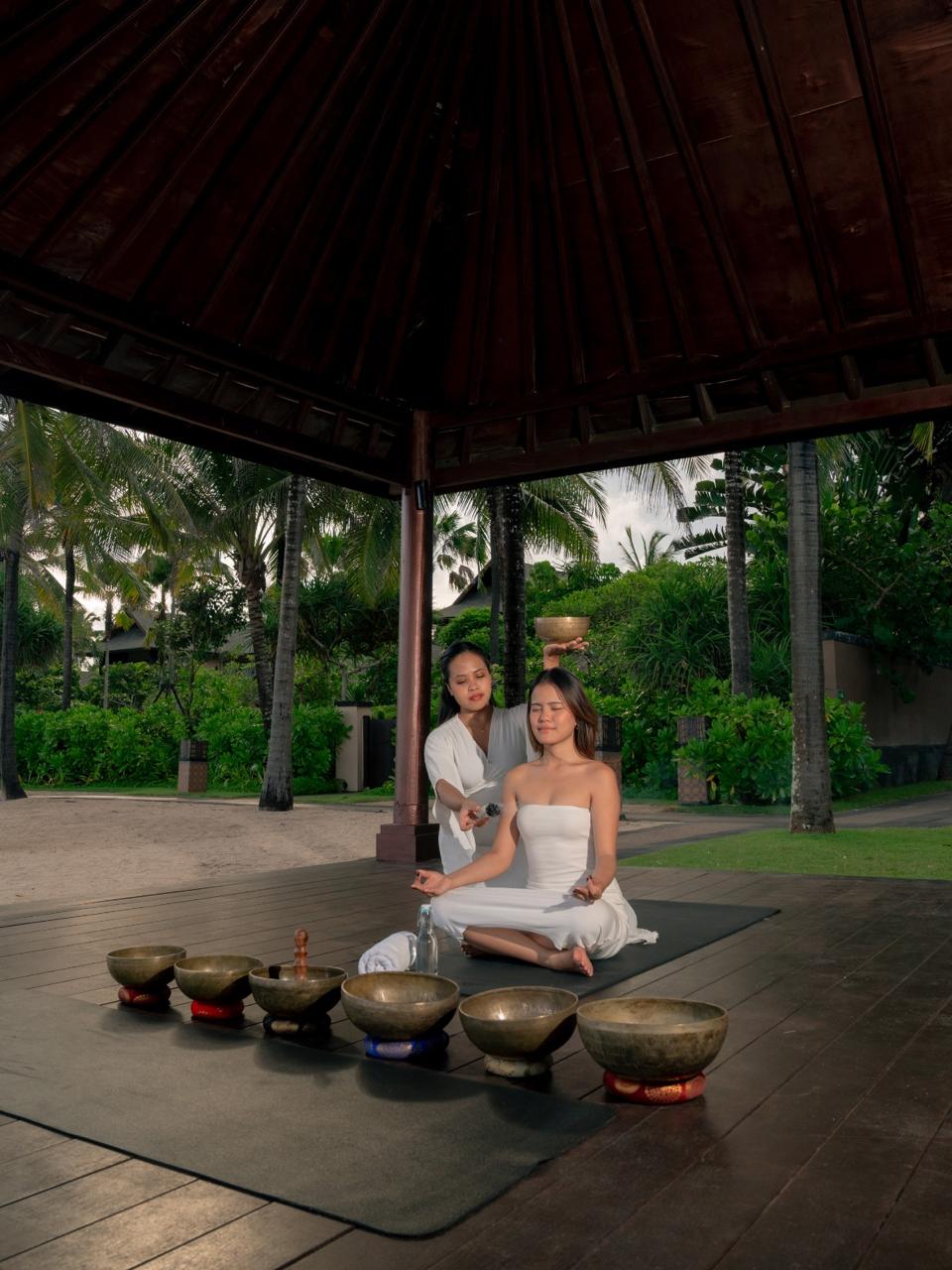 Woman preparing a healthy meal with fresh ingredients and herbal tea in a cozy kitchen filled with natural light.