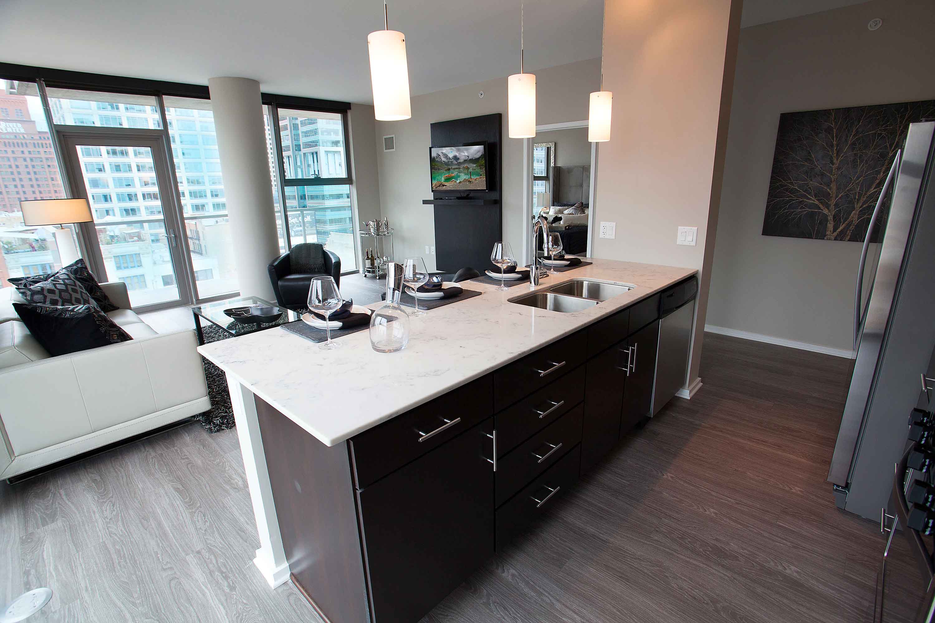 Kitchen island and living room at Catalyst luxury West Loop Chicago apartments