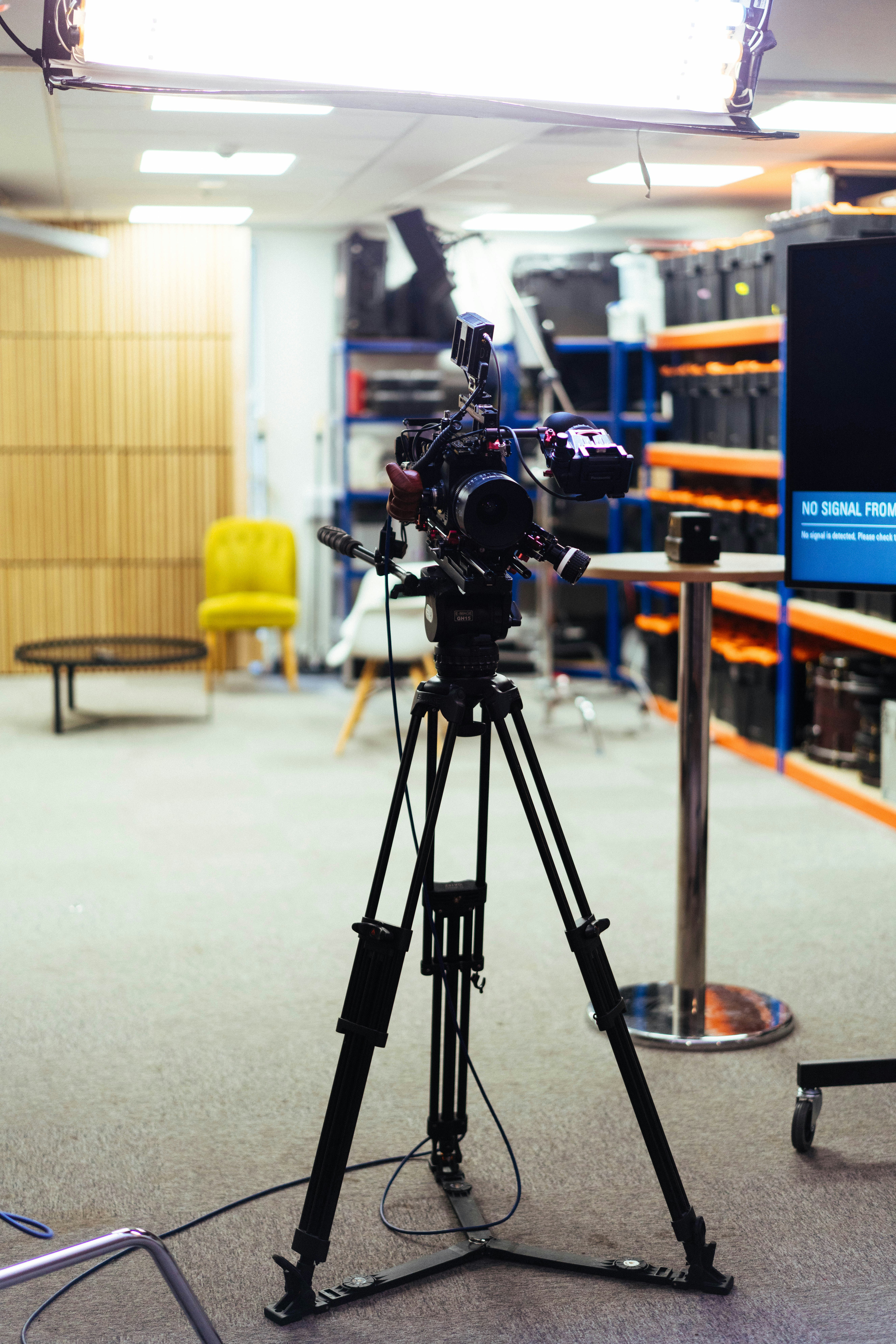 Professional video camera on a tripod in a studio.