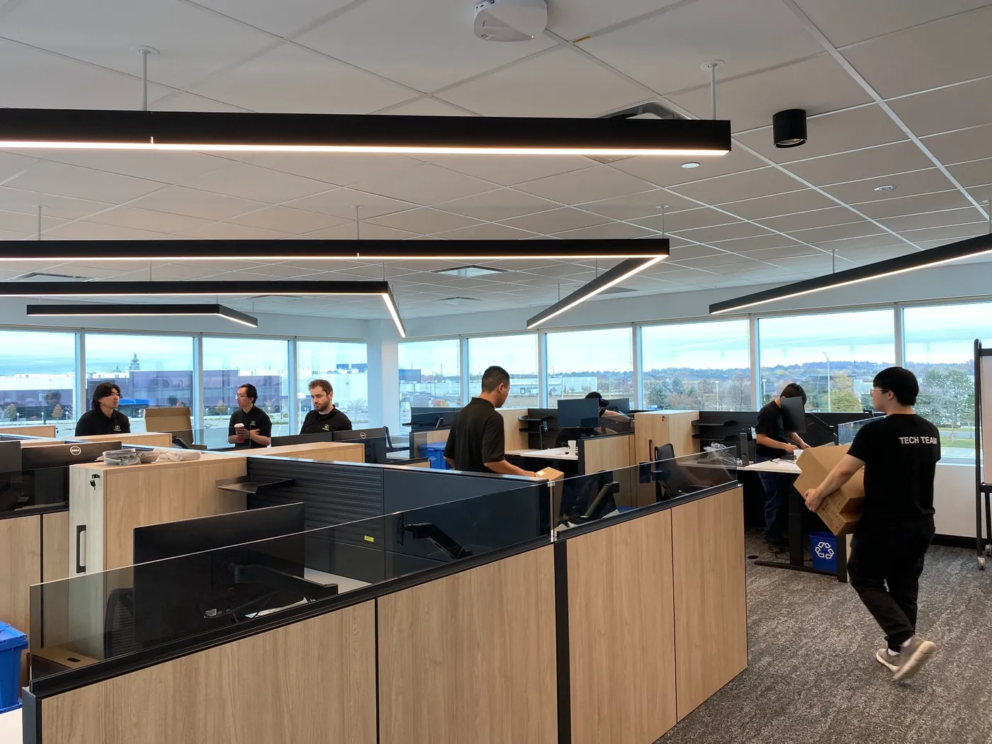 Office IT installation with team deploying workstations, monitors, and equipment in corporate workspace.