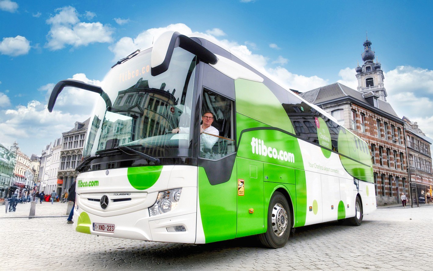 Flibco airport transfer bus in a European city square.