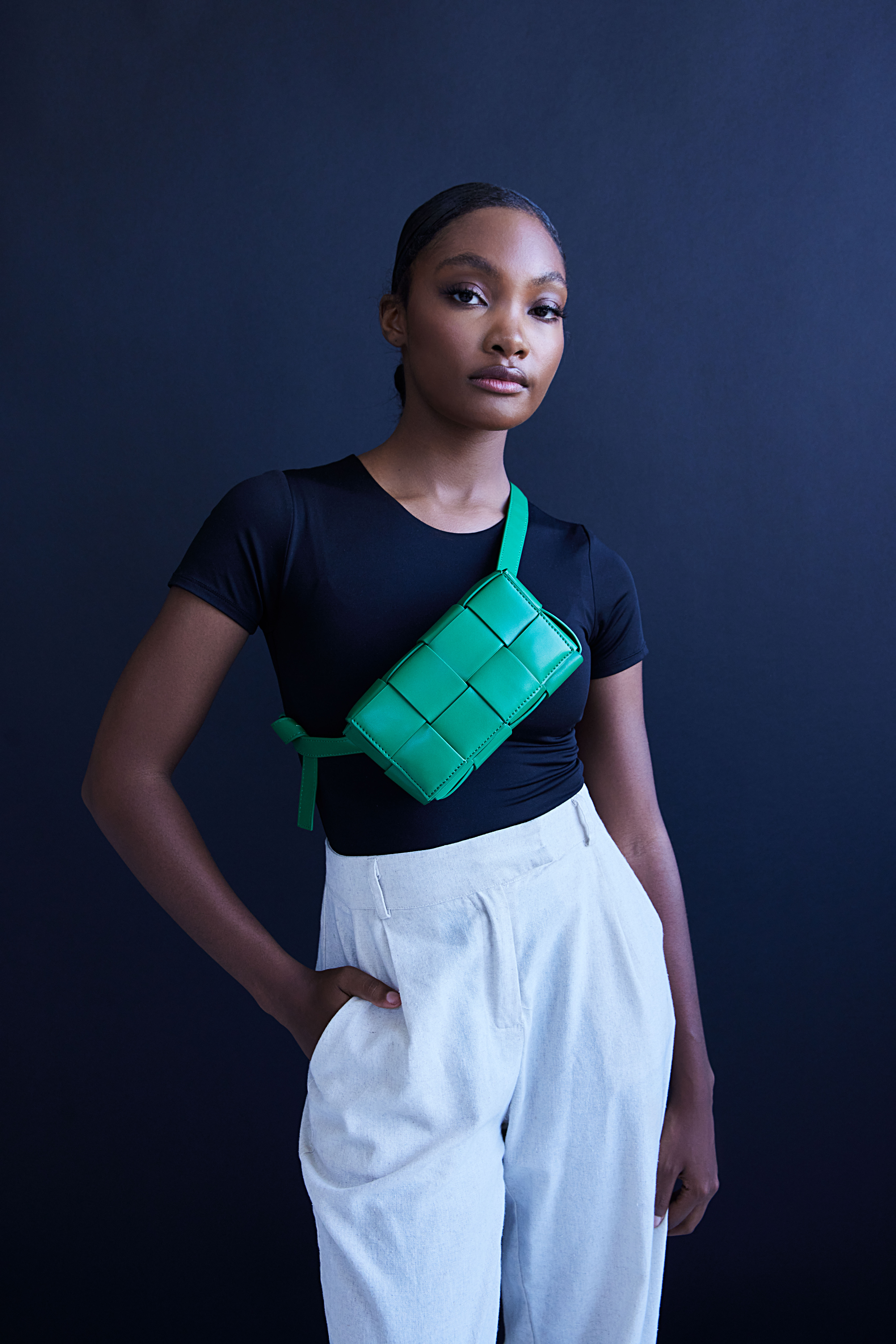 A tan sighthound stands in a grassy field.