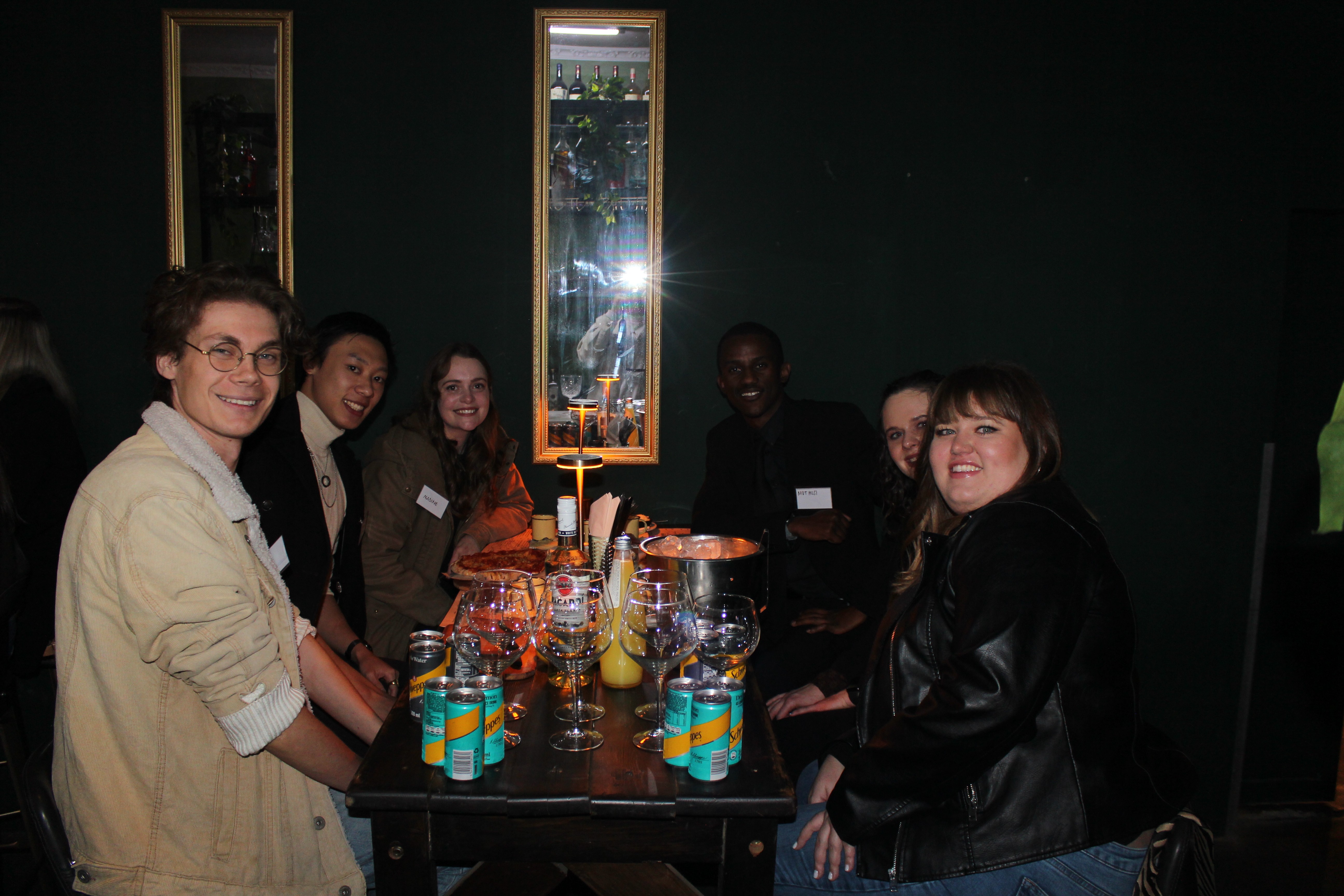 Group of people smiling and having drinks