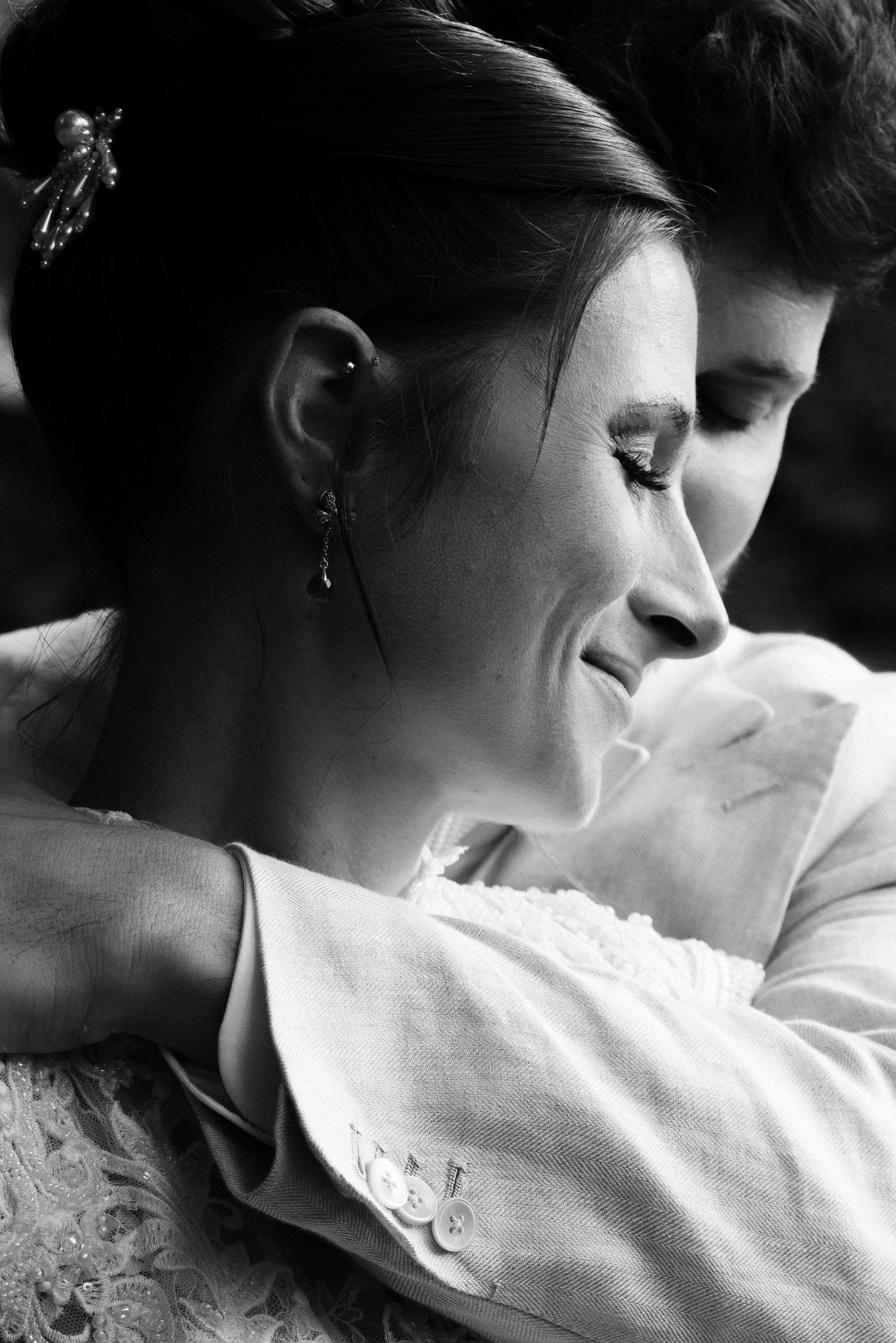 Sposa abbracciata allo sposo, volto di emozione, profilo in bianco e nero dopo la cerimonia alla Rocca di Soragna
