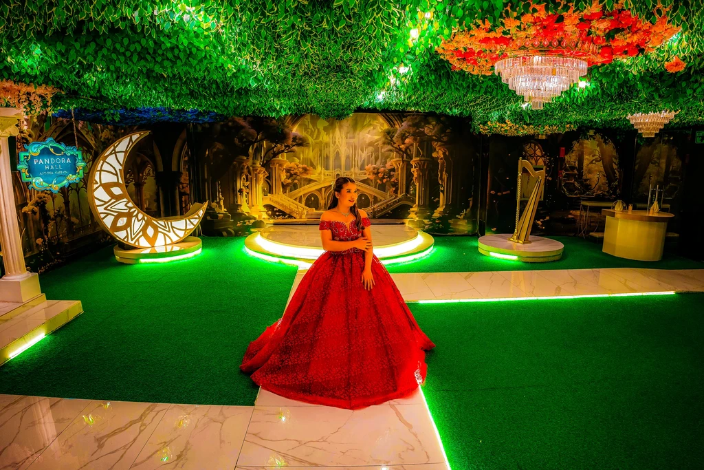 Debutante in a flowing red gown crossing Pandora Hall's enchanted stage