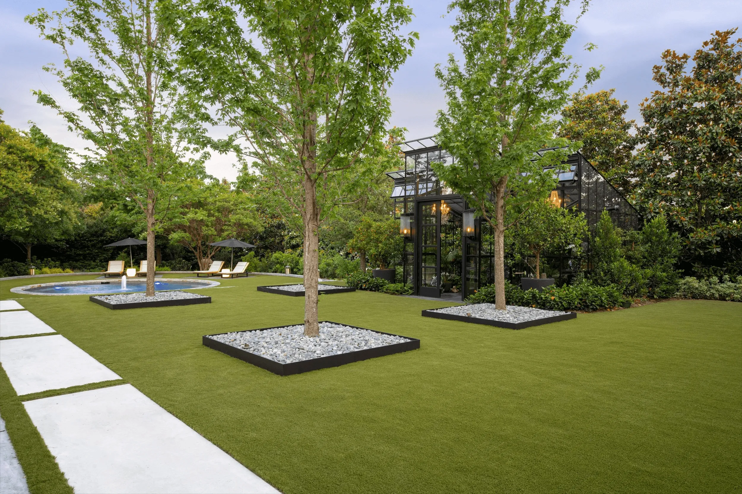 Symmetrical front yard landscape design with geometric walkway and matching planters at French country home in Park Cities Dallas