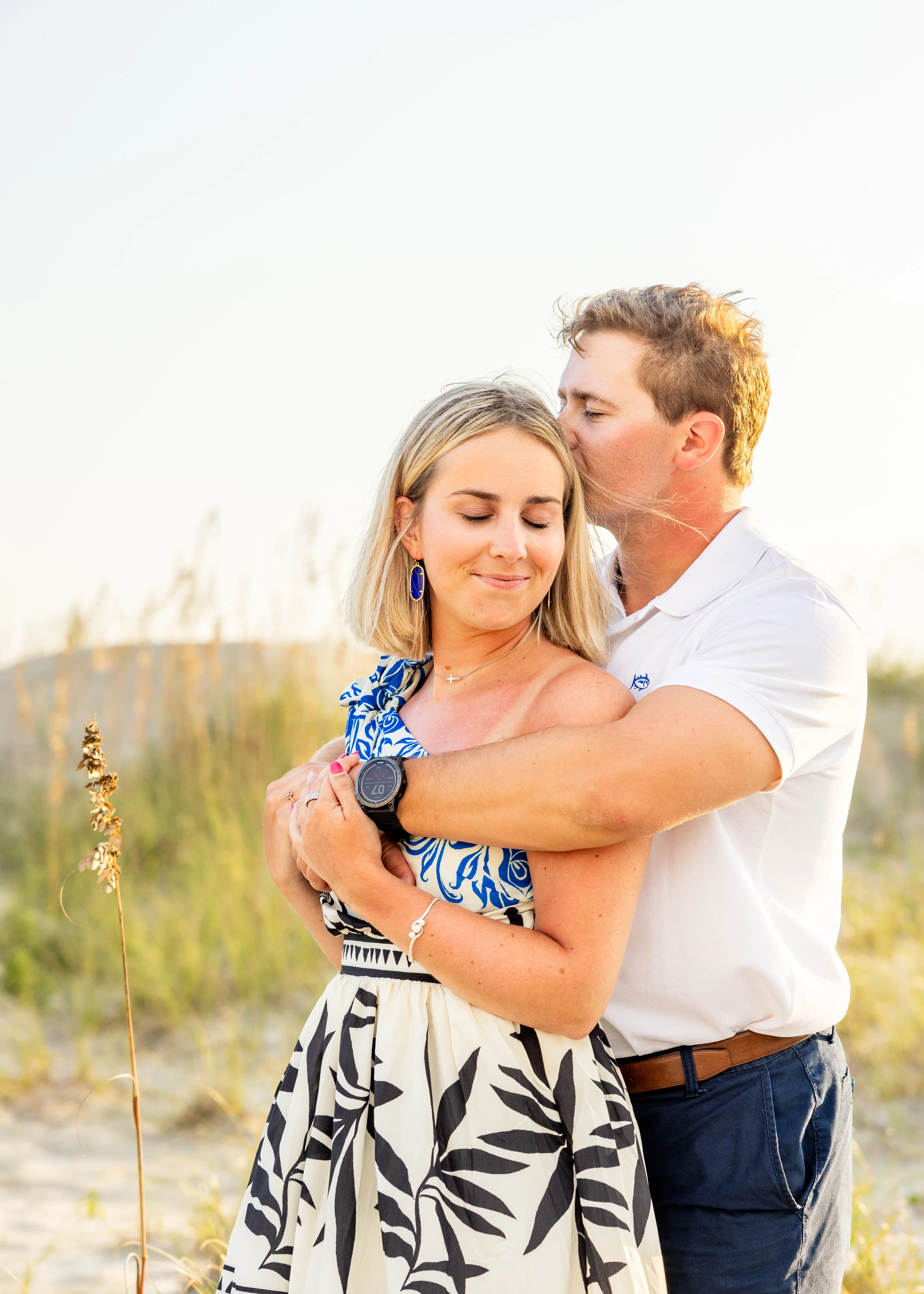 Emilee and Lyle embracing in the dunes