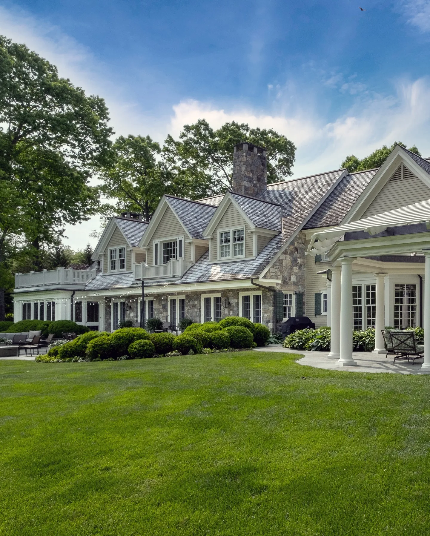 A grand house with a well-maintained lawn and multiple windows.