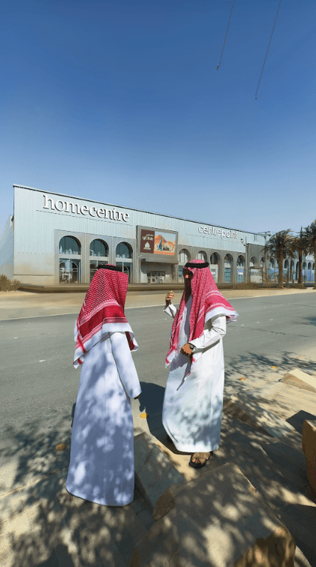 A real-world photo of two men standing outside a Homecentre location in daylight