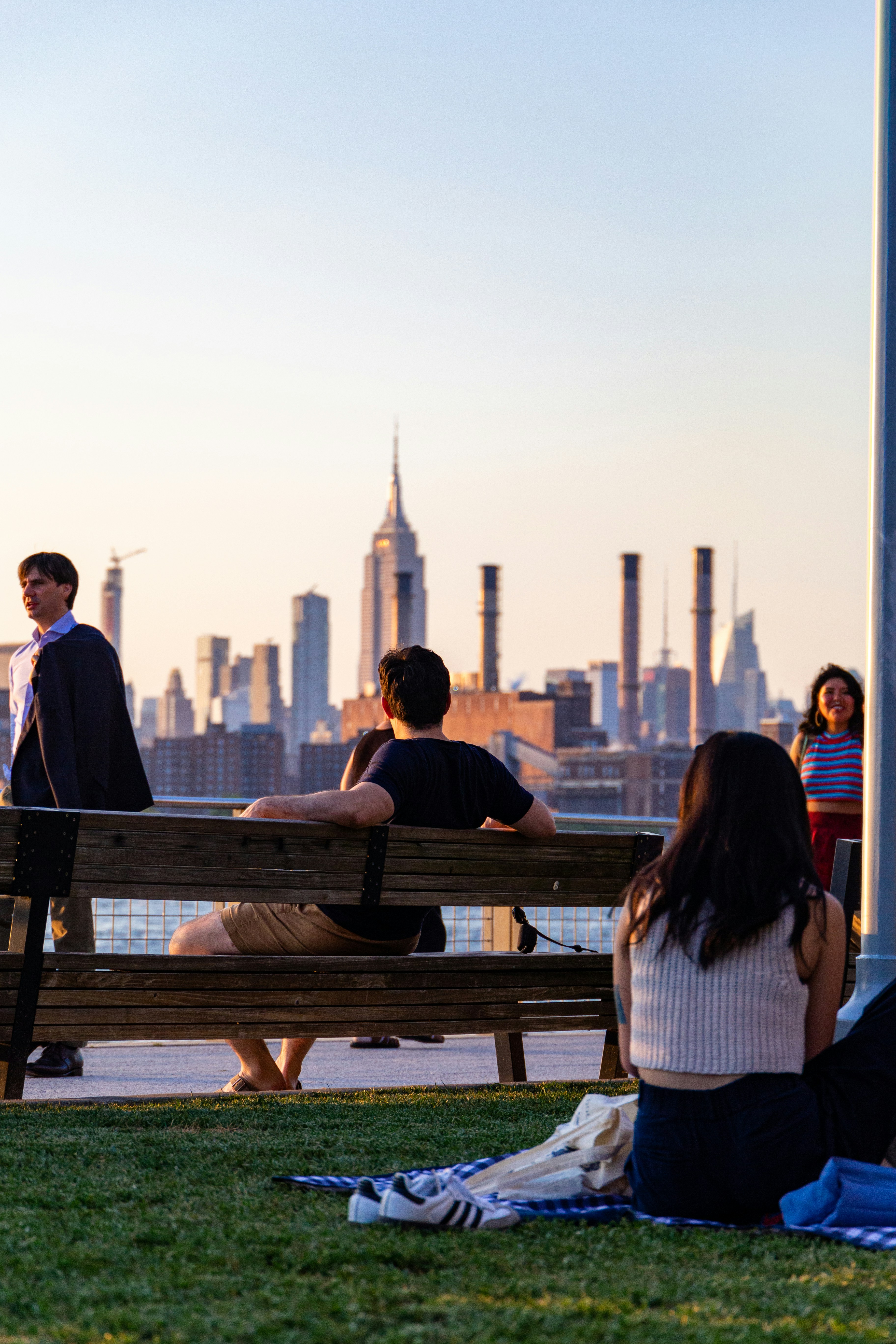 People relaxing with cityscape in background at sunset representing online support, reflection, and gender exploration therapy with affirming care