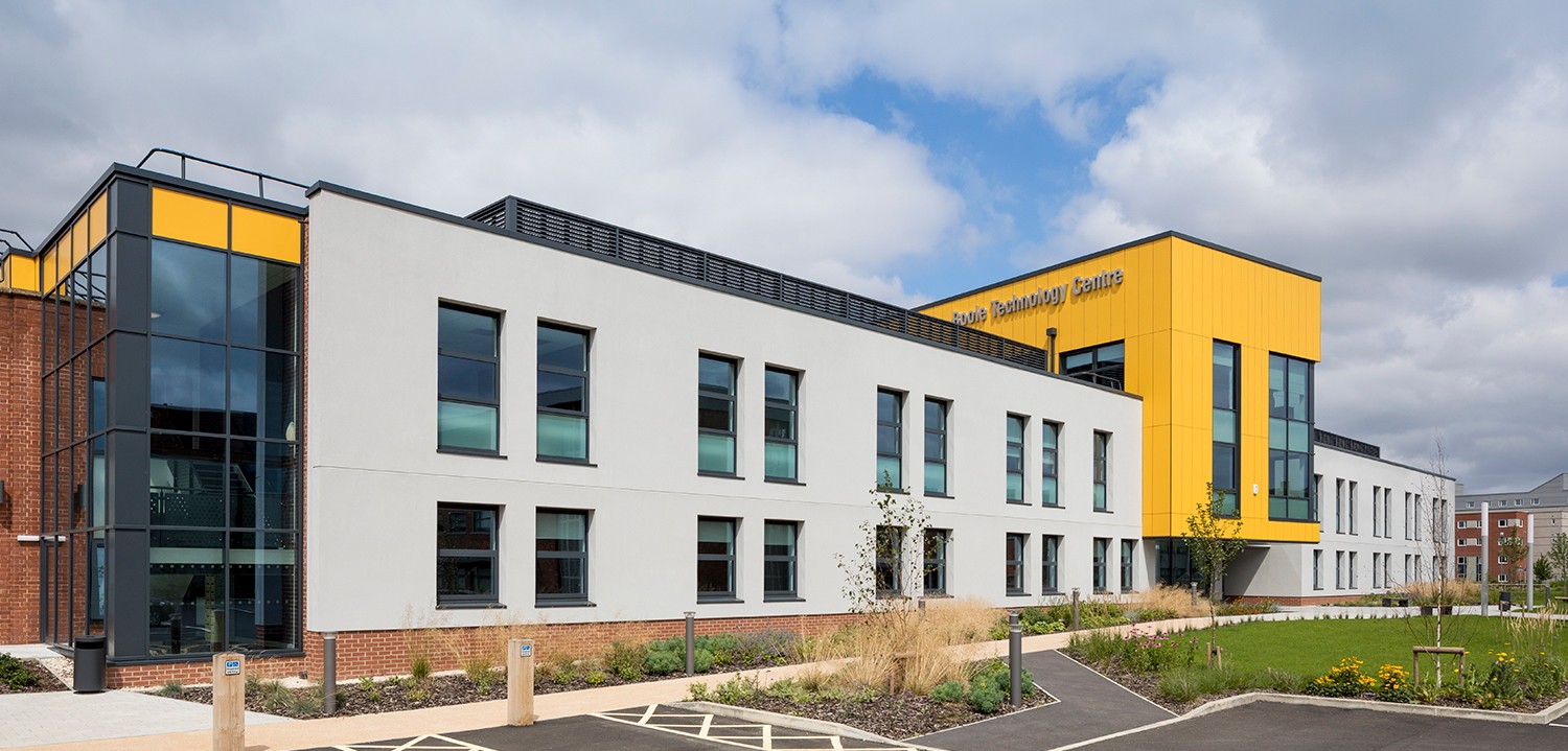 Contemporary Boole Technology Centre building with white and yellow exterior, multiple windows, and landscaped grounds