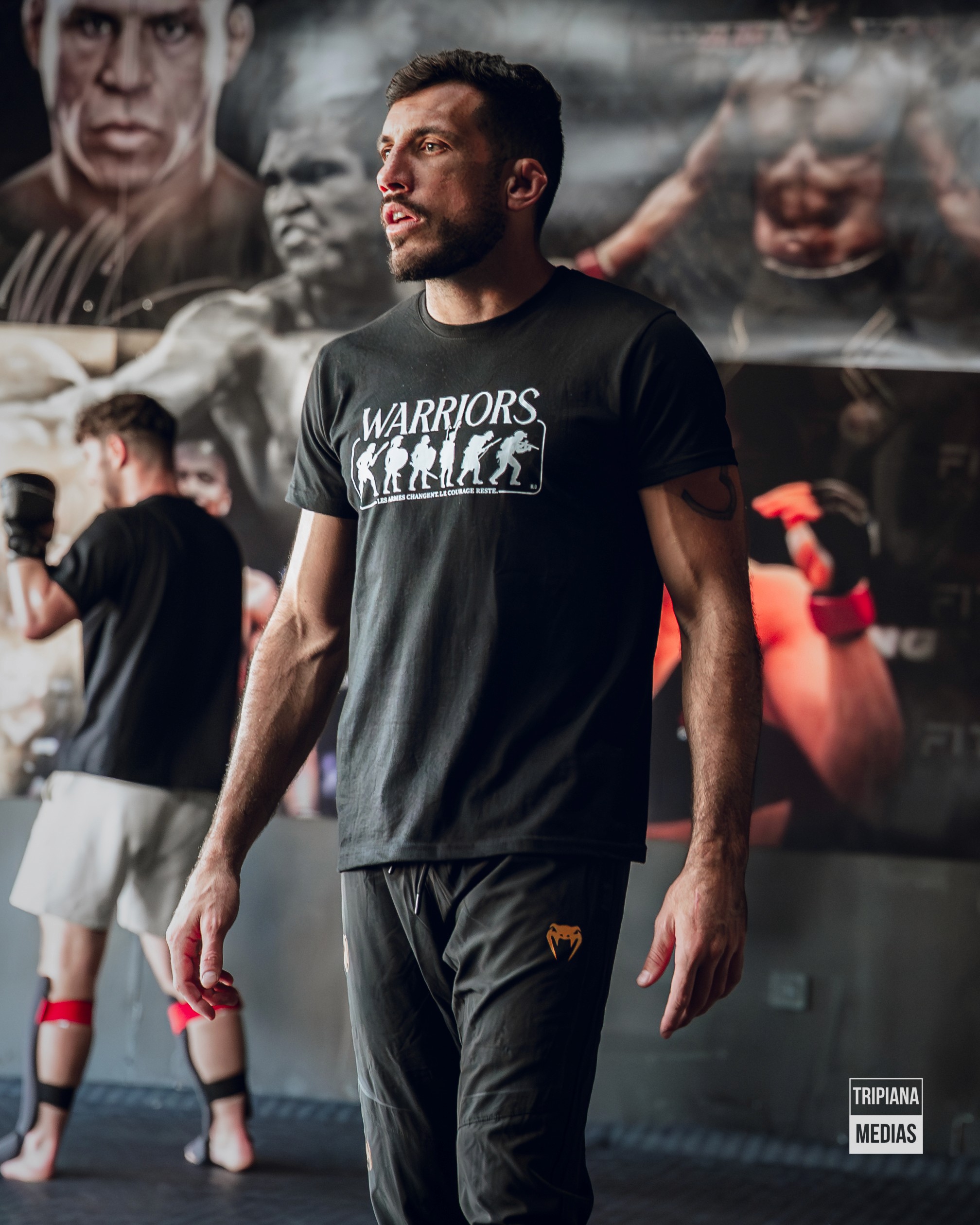 woman in black and white shirt and black shorts standing on black and red boxing gloves