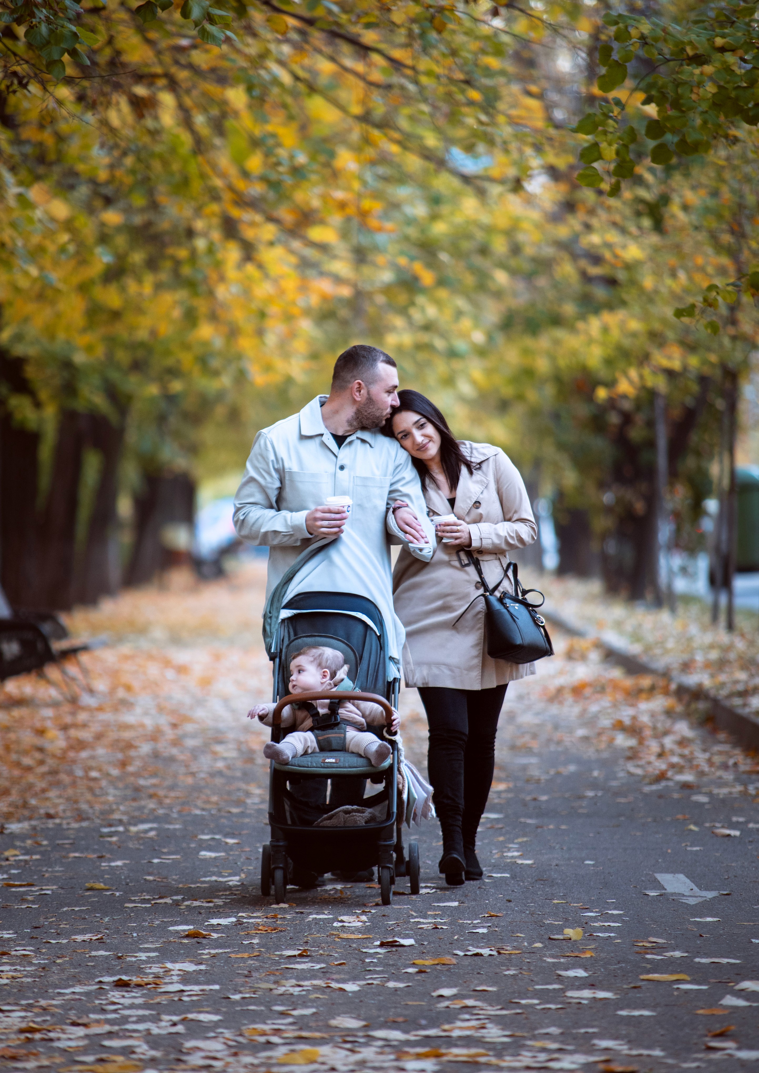 Fotografie de familie în București, plimbare de toamnă cu părinți și copil în cărucior.