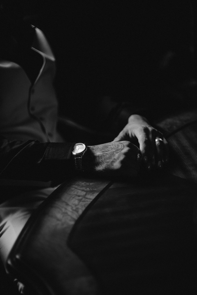 a black and white photo of a person's hand resting on a chair