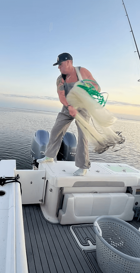 Crew throwing a cast net for live bait at first light