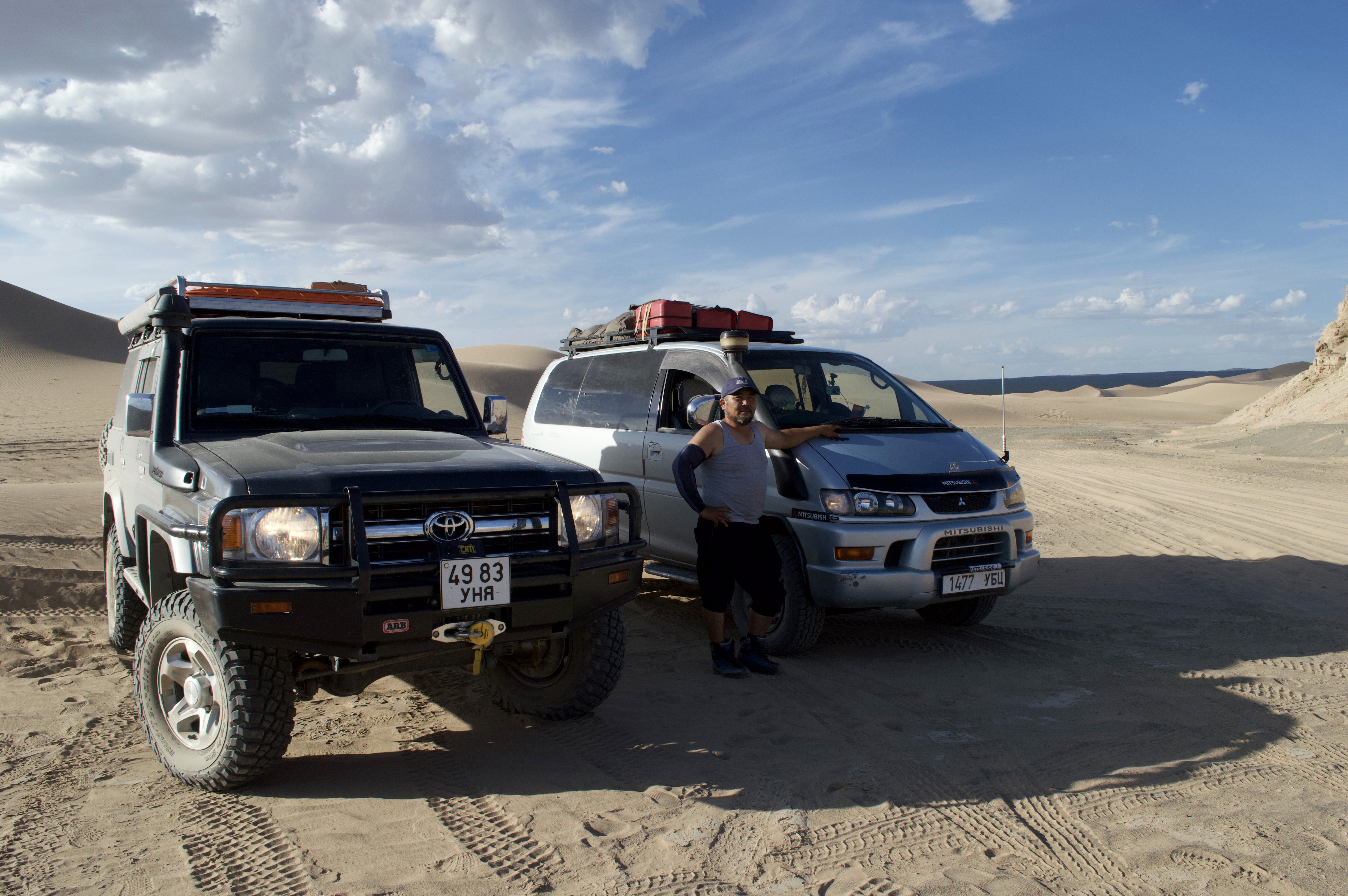 Tourguide in Mongolia with off-road cars in Gobi desert
