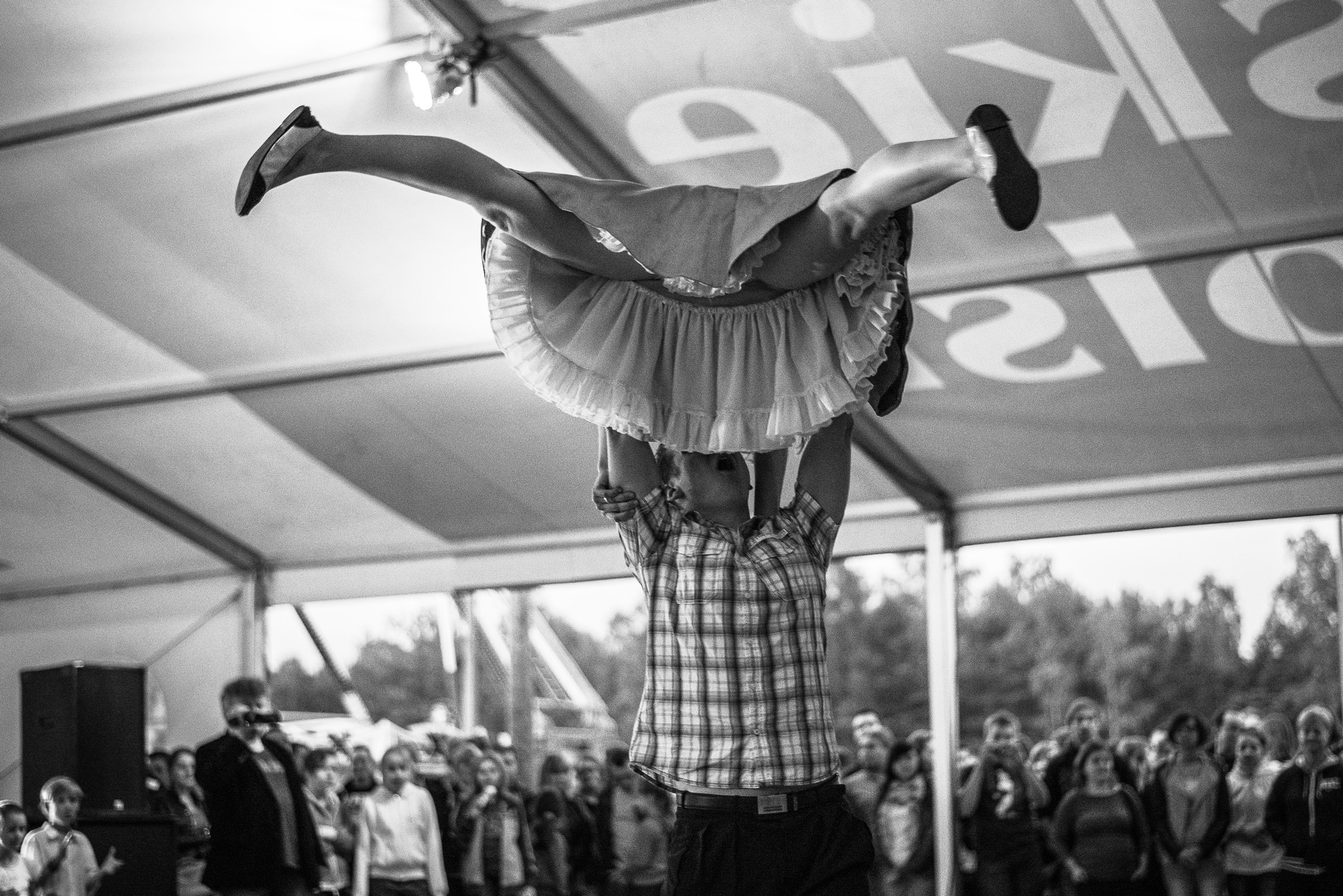 Czarno-biały kadr z festynu. Para tańczy Rock'n'rolla na turnieju.