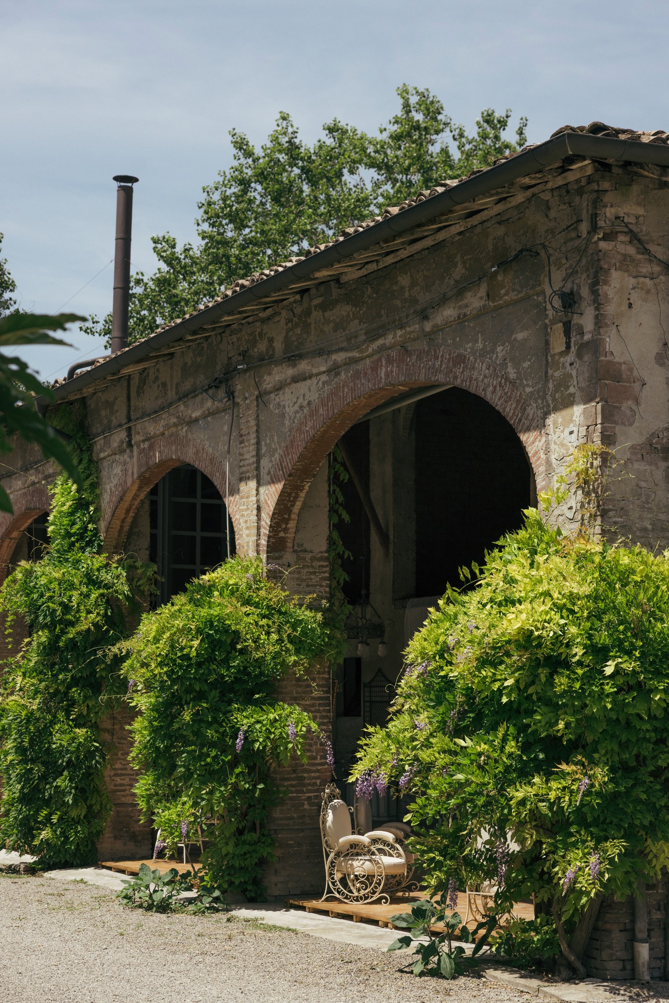 Facciata in laterizio di villa con ampi archi e edera verde, luce naturale sui preparativi matrimoniali