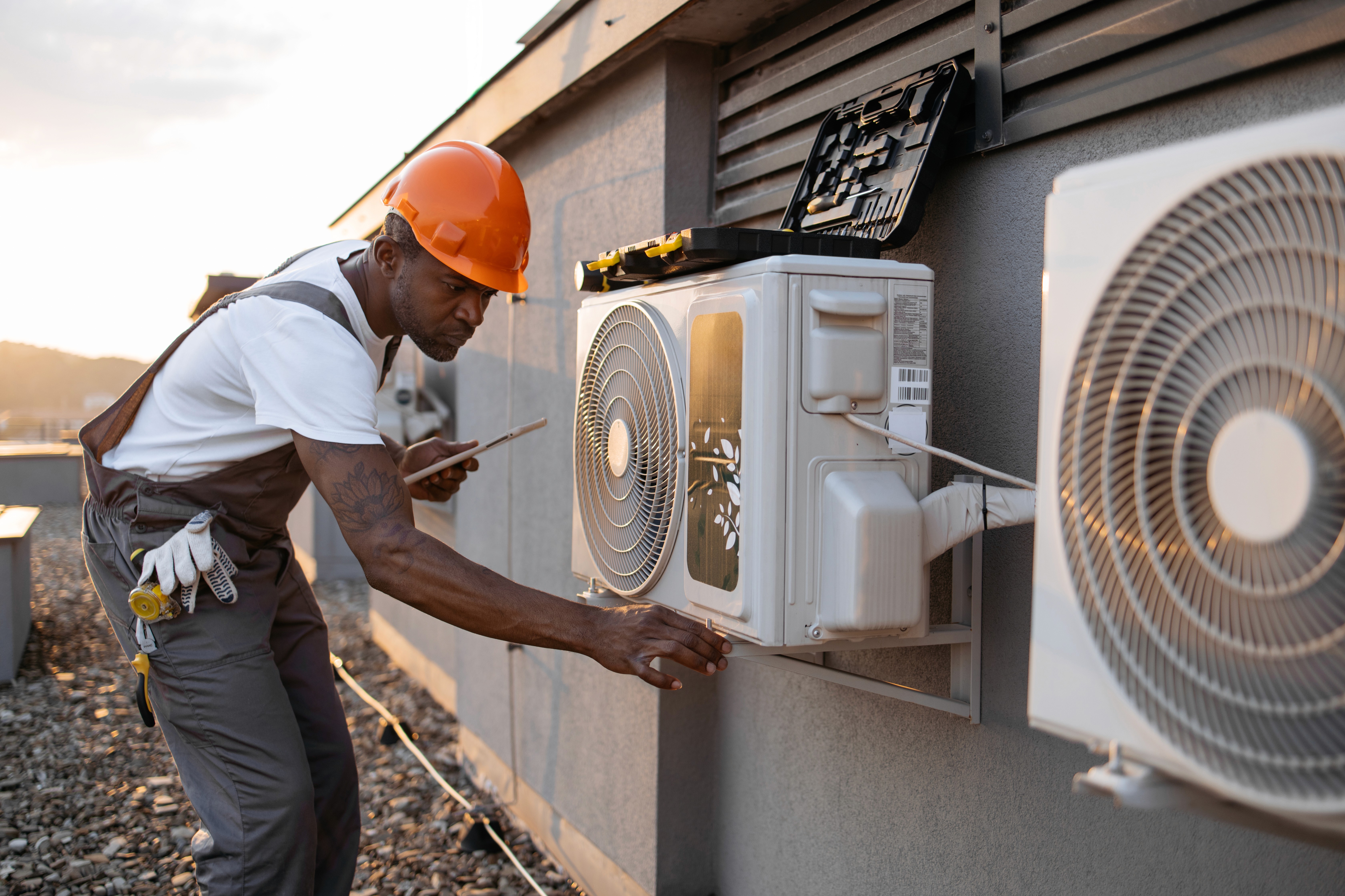 Professional HVAC technician performing heat pump inspection and maintenance on outdoor condenser