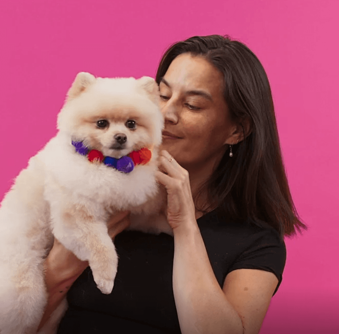 Happy woman hugging her small white dog to reflect warmth, connection, and gentle grooming experience.