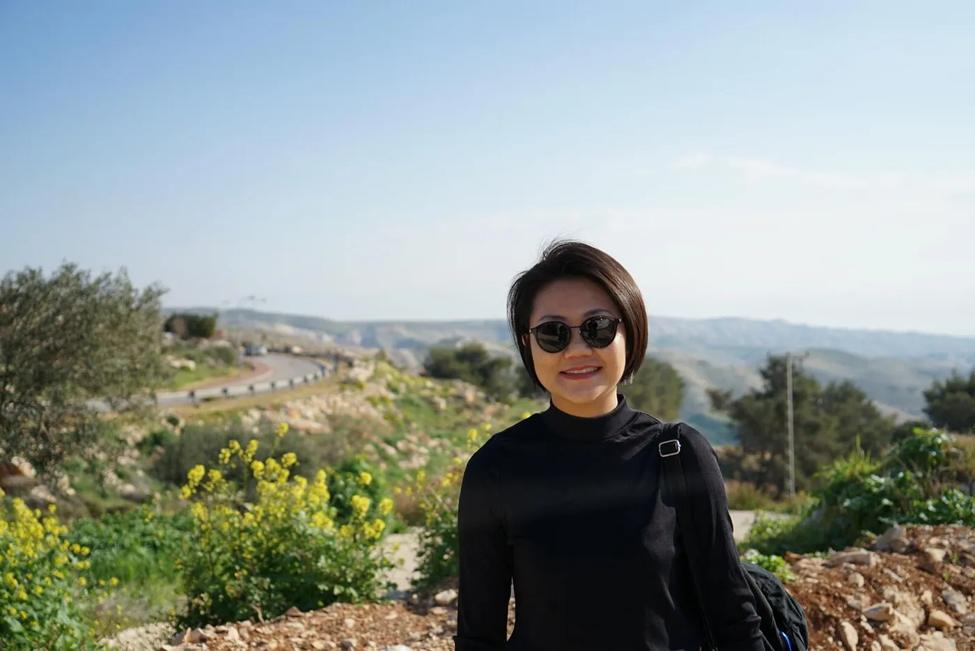 Kaimin wearing sunglasses standing on a mountain