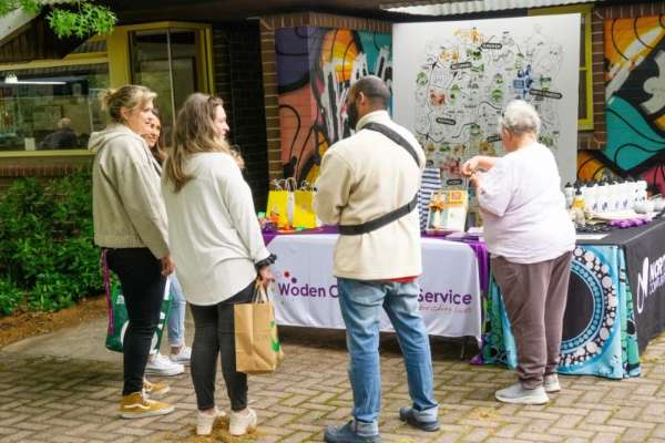People talking to each other about mental health at a wellbeing BBQ event.