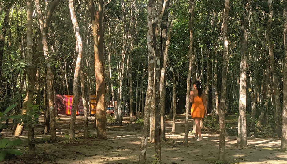 Woman walking in forest in orange mid length dress