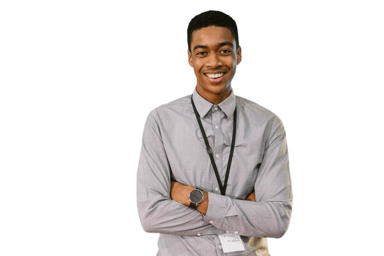 A smiling young man in a light gray button-up shirt stands with his arms crossed, wearing a lanyard and watch.