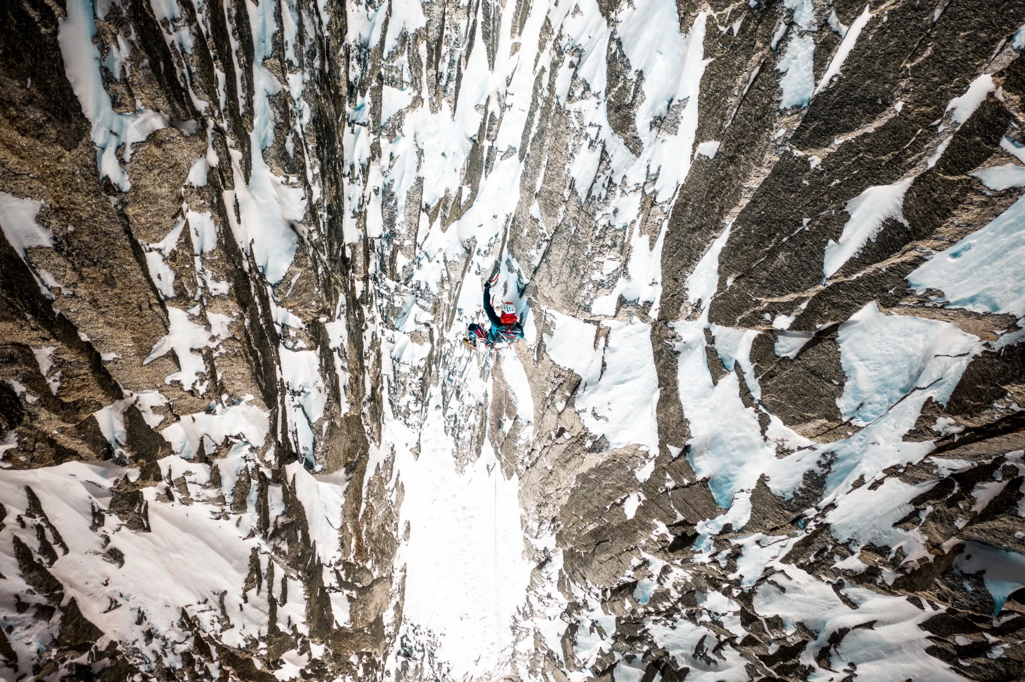 Apiniste équipé Millet escaladant une paroi de glace dans le massif du Mont-Blanc