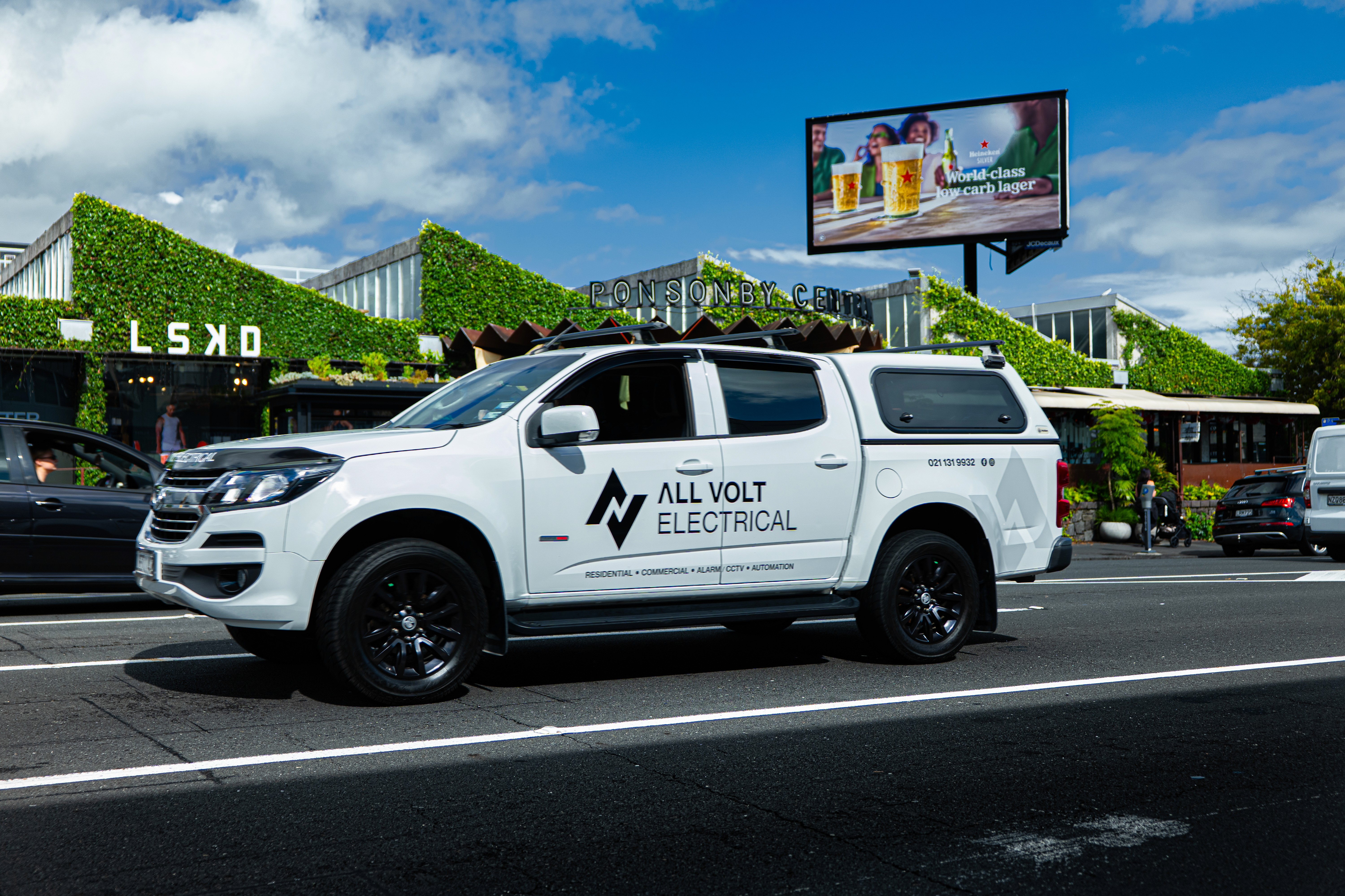 Modern living room with vertical garden, yellow sofas, and stylish coffee tables.