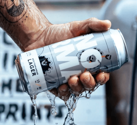 Close-up of a yellow tennis ball sitting on a green court, positioned near the white center line.