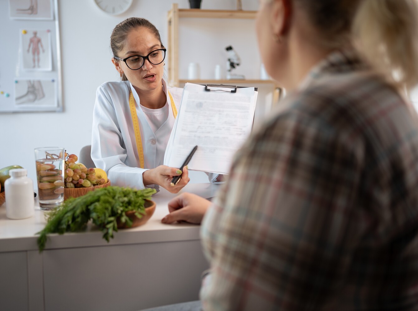 woman discussing a wellness routine with a dietitian to best fit in using a steam room for fat loss