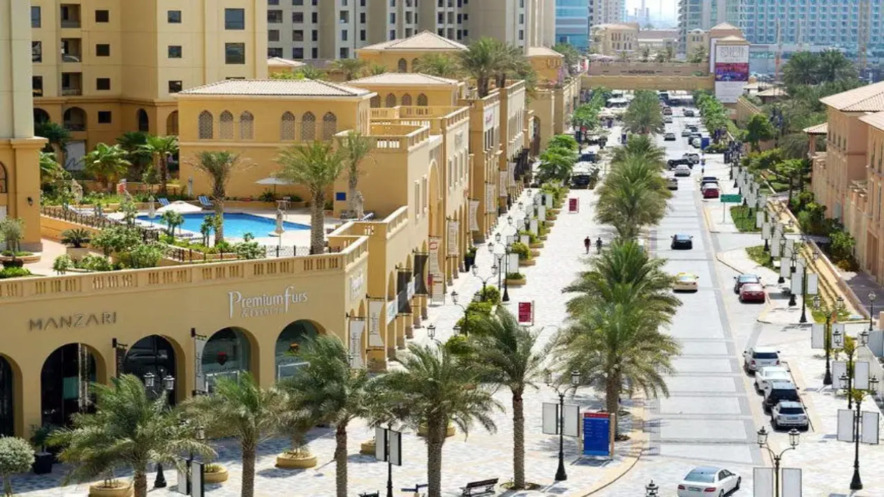 A vibrant pedestrian walkway with shops and palm trees, showcasing the urban lifestyle within the Majan community.