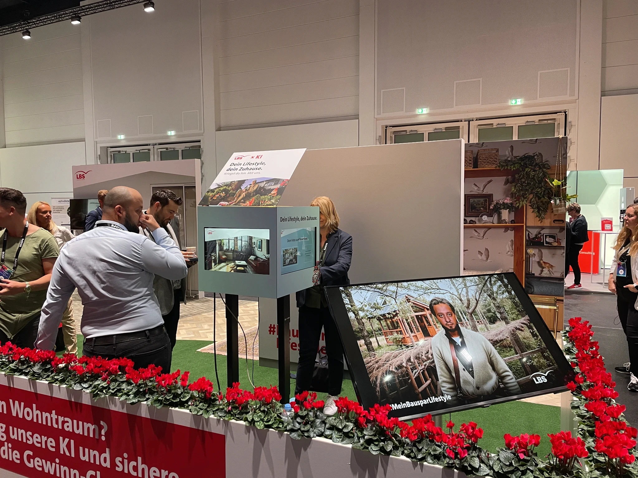 Besucher nutzen ein SnapCube Fotomodul auf einem Messestand mit interaktivem Bildschirm und digitaler Präsentationsfläche.